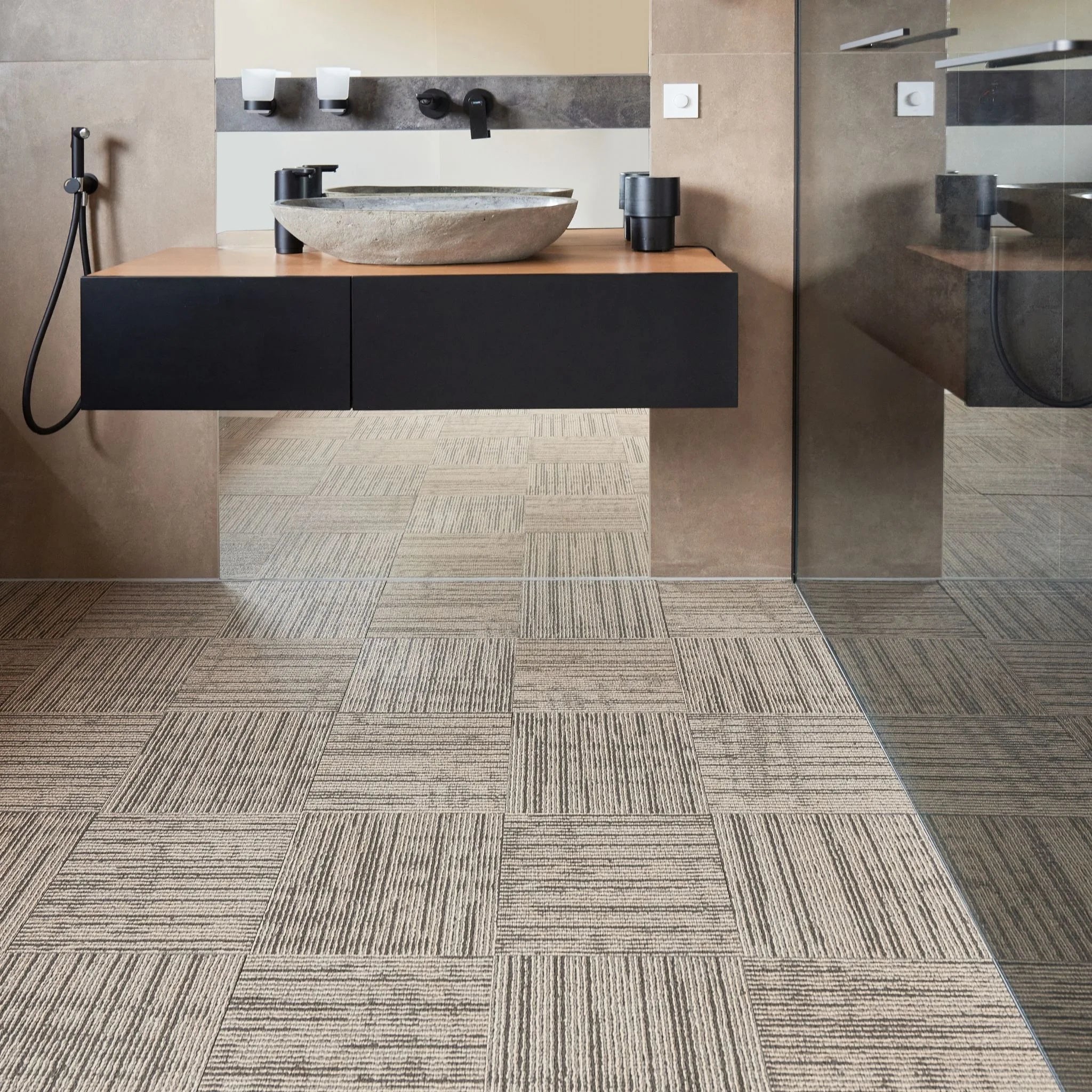 modern bathroom with black vanity, textured beige floor, and minimal accessories