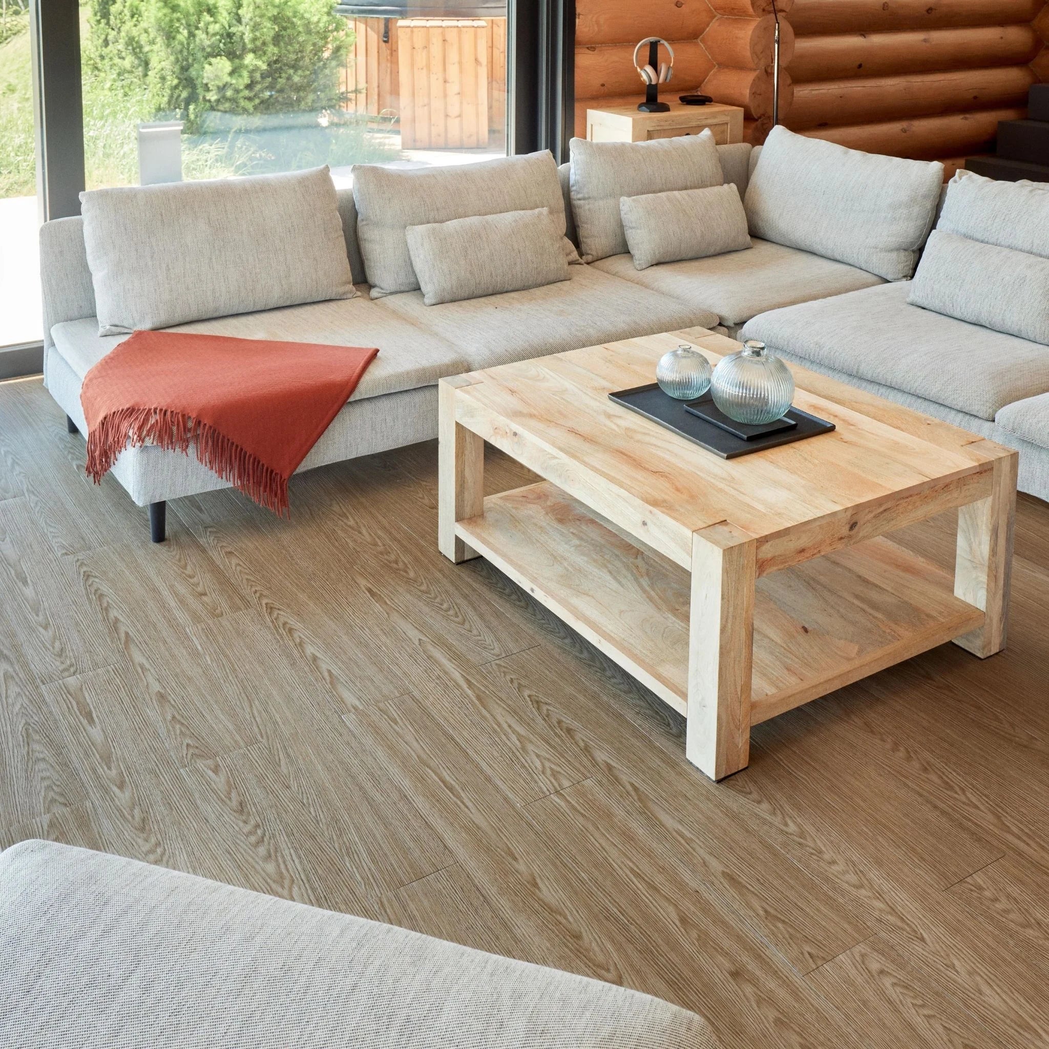 contemporary living room with large beige sofa, wooden coffee table, and light wood flooring