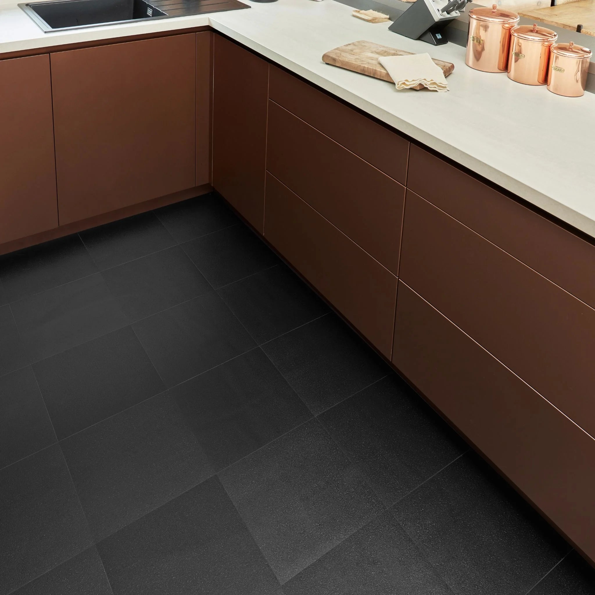 contemporary kitchen featuring brown kitchen furniture with black flooring
