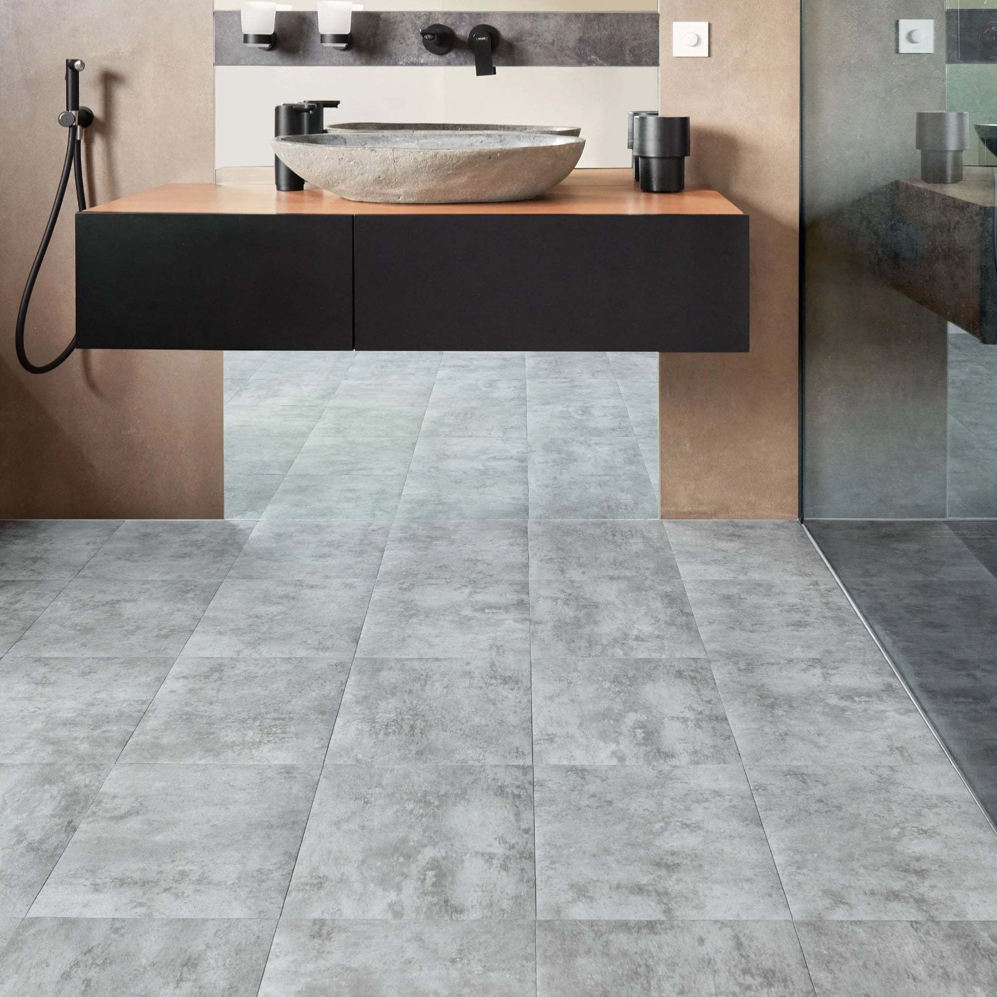 modern bathroom with black vanity, textured grey floor, and minimal accessories