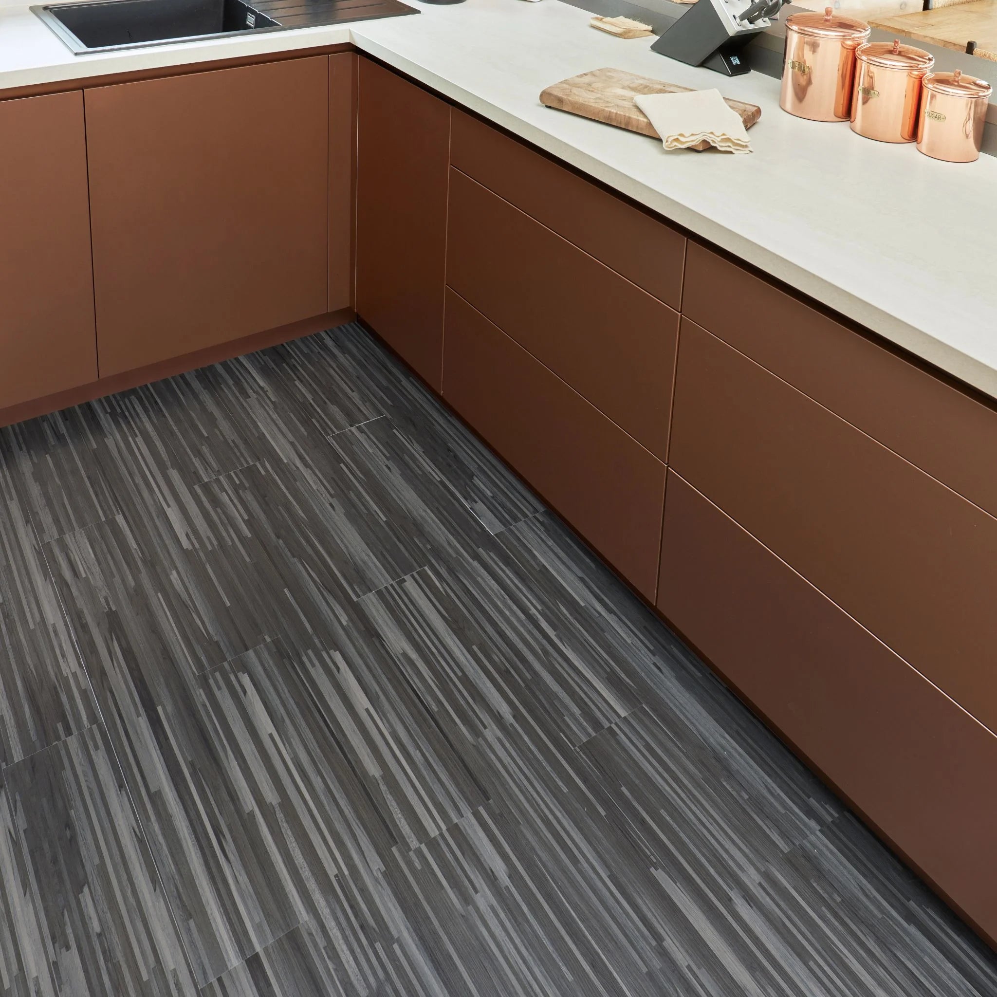 contemporary kitchen featuring brown kitchen furniture with dark grey flooring