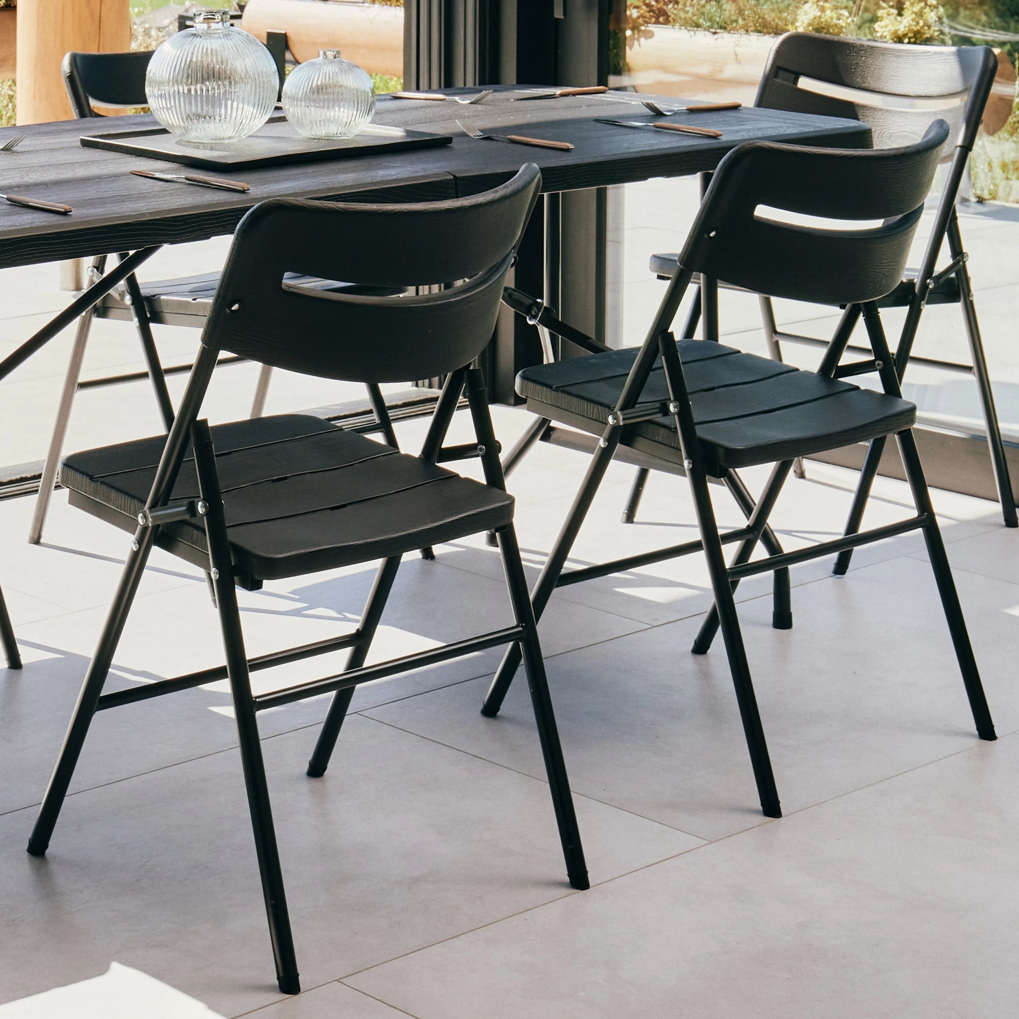 black folding chair on patio with a scenic view