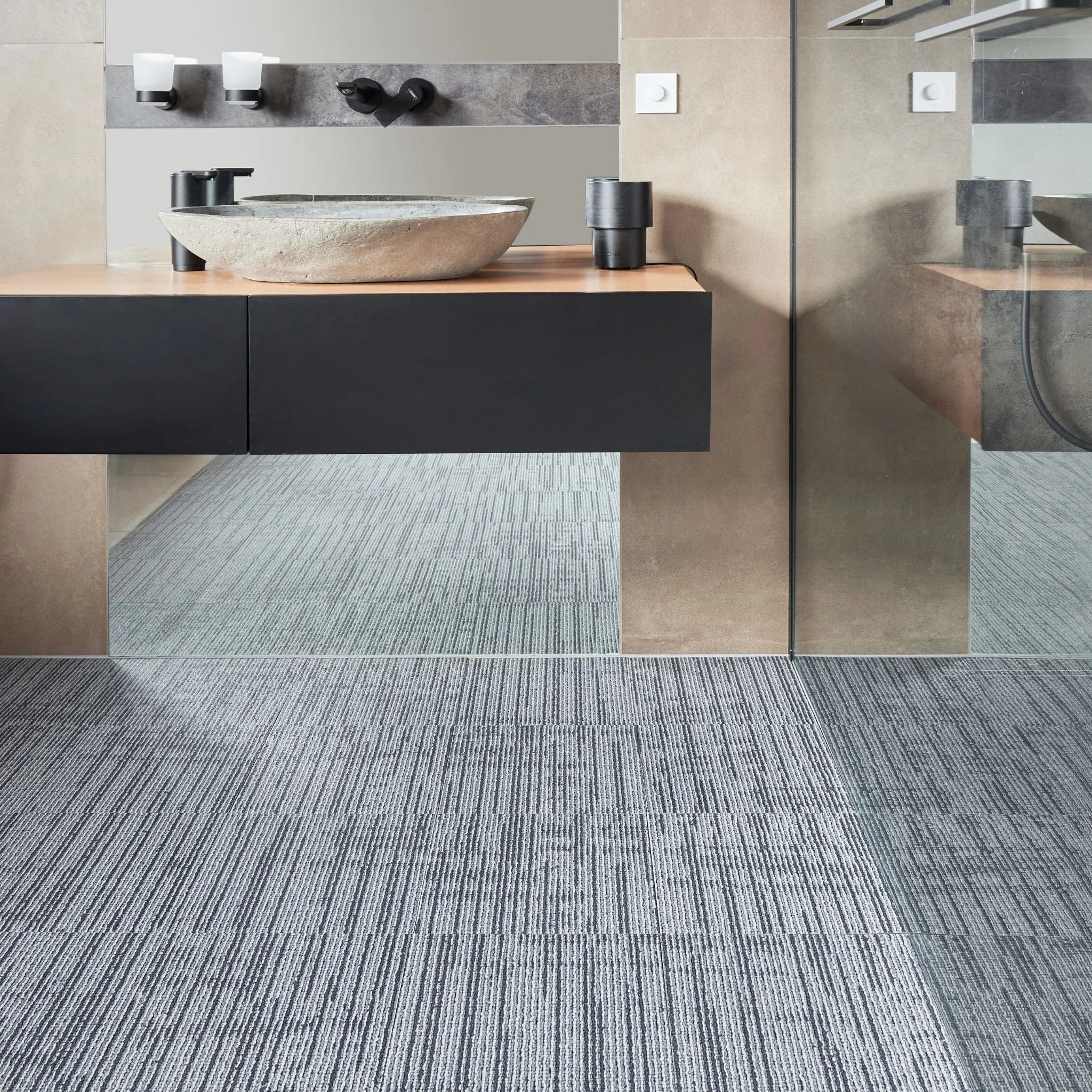 modern bathroom with black vanity, textured grey floor, and minimal accessories