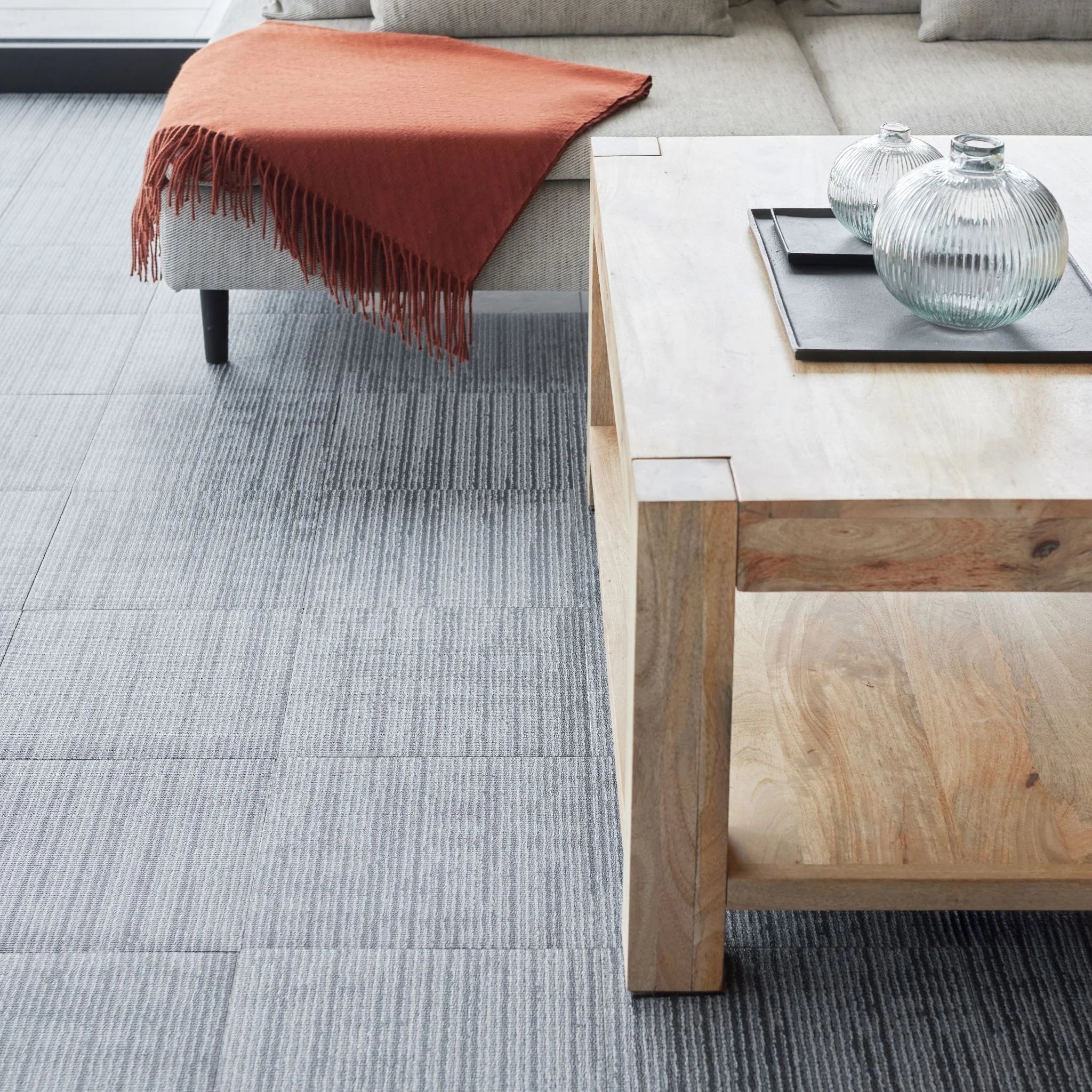 contemporary living area with grey carpet flooring and rustic wooden furniture