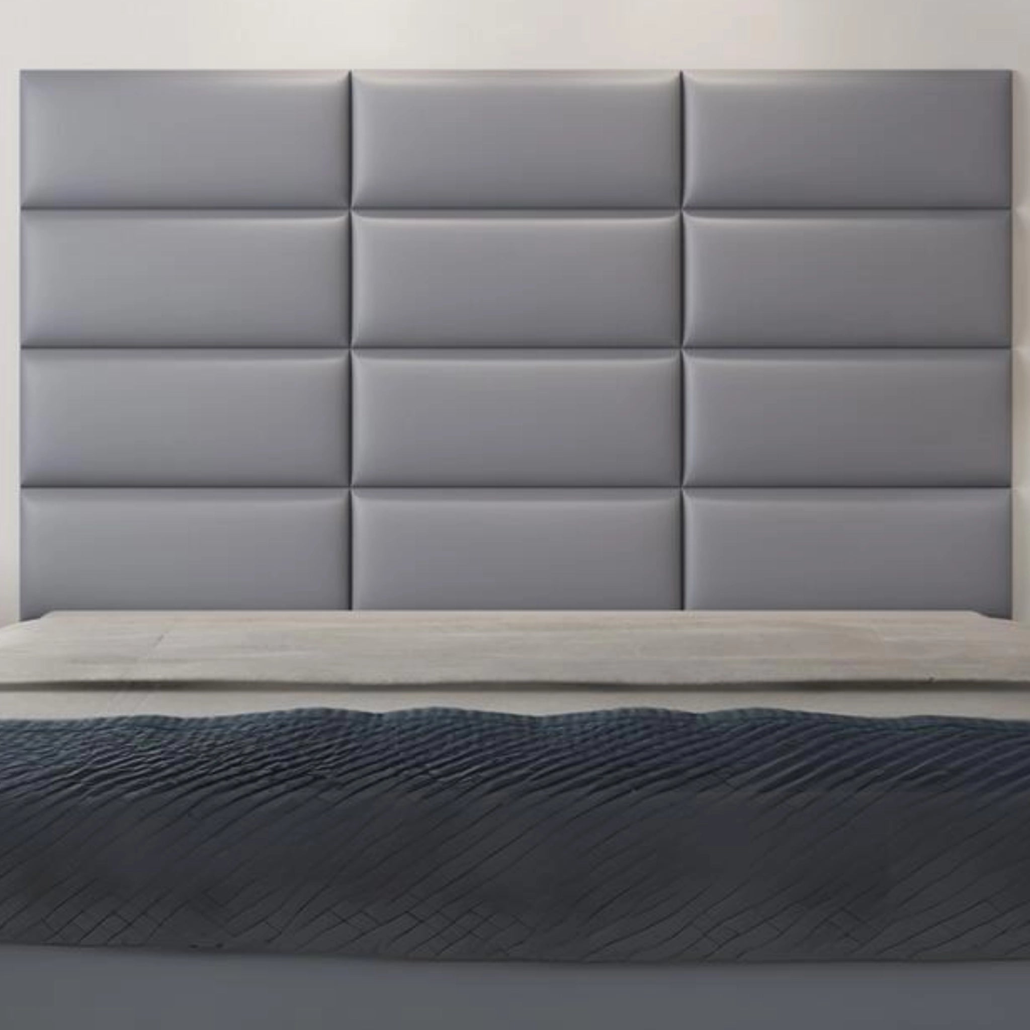 Modern bedroom with grey upholstered wall panel featuring padded surface