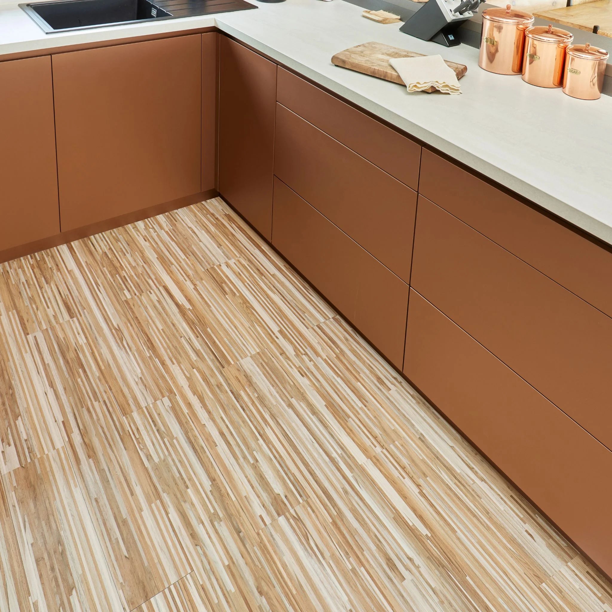 contemporary kitchen featuring brown kitchen furniture with beige flooring