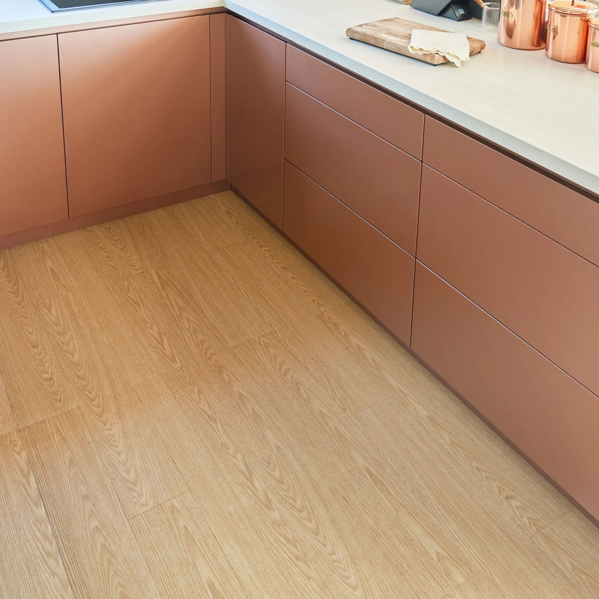 modern kitchen corner with brown cabinets and light brown wood-effect flooring