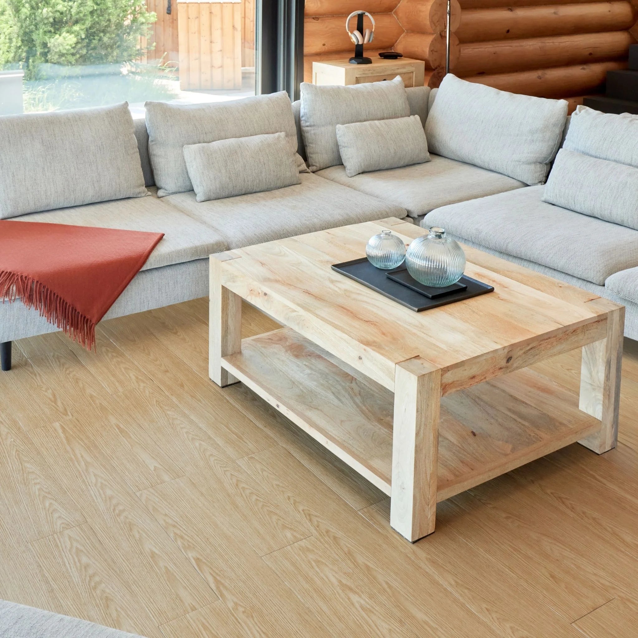 contemporary living room with large beige sofa, wooden coffee table, and light brown wood flooring