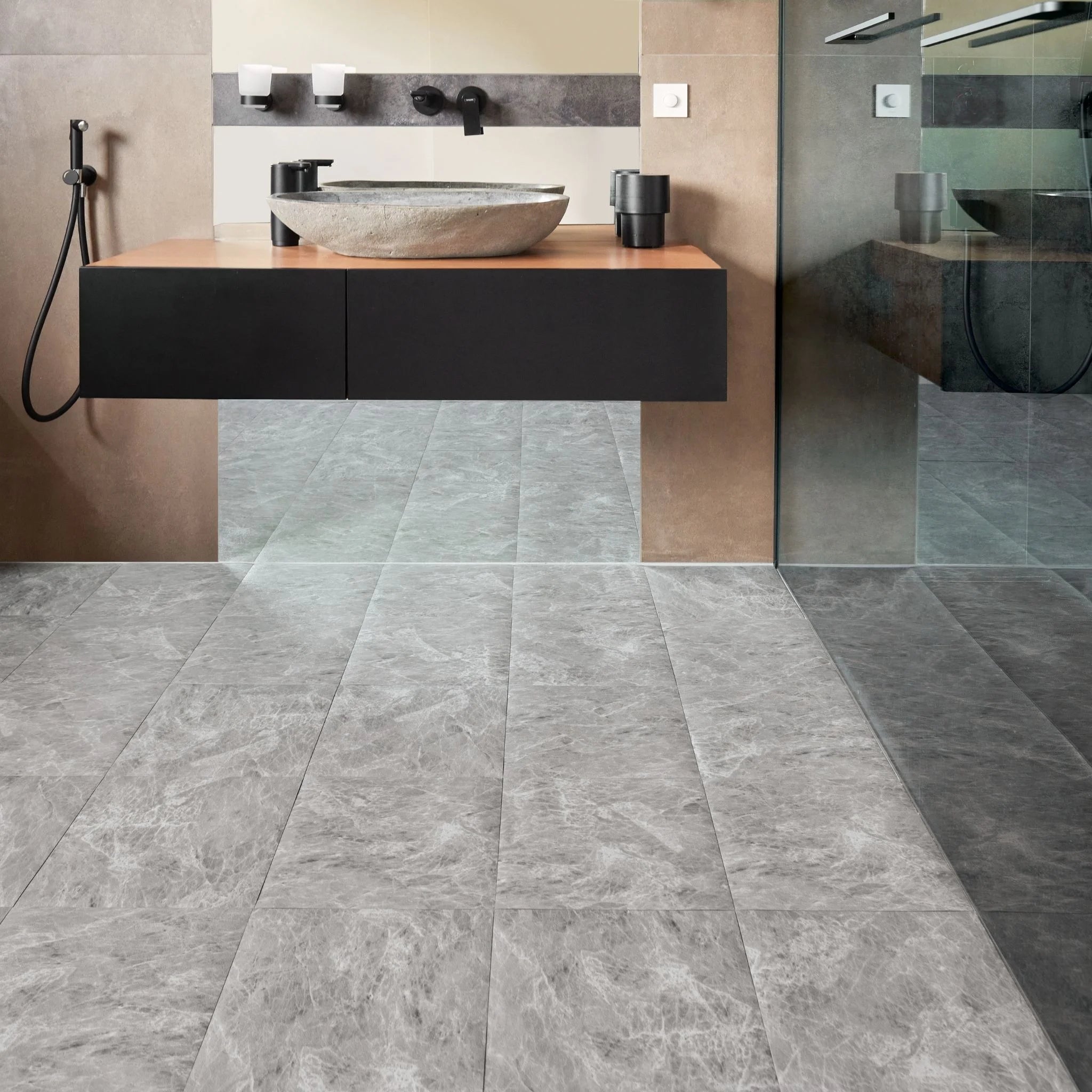 modern bathroom with black vanity, textured light grey floor, and minimal accessories