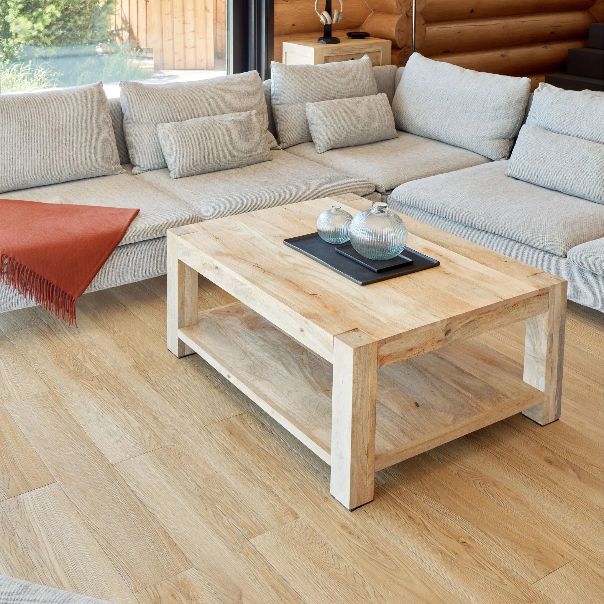contemporary living room with large beige sofa, wooden coffee table, and light brown wood flooring