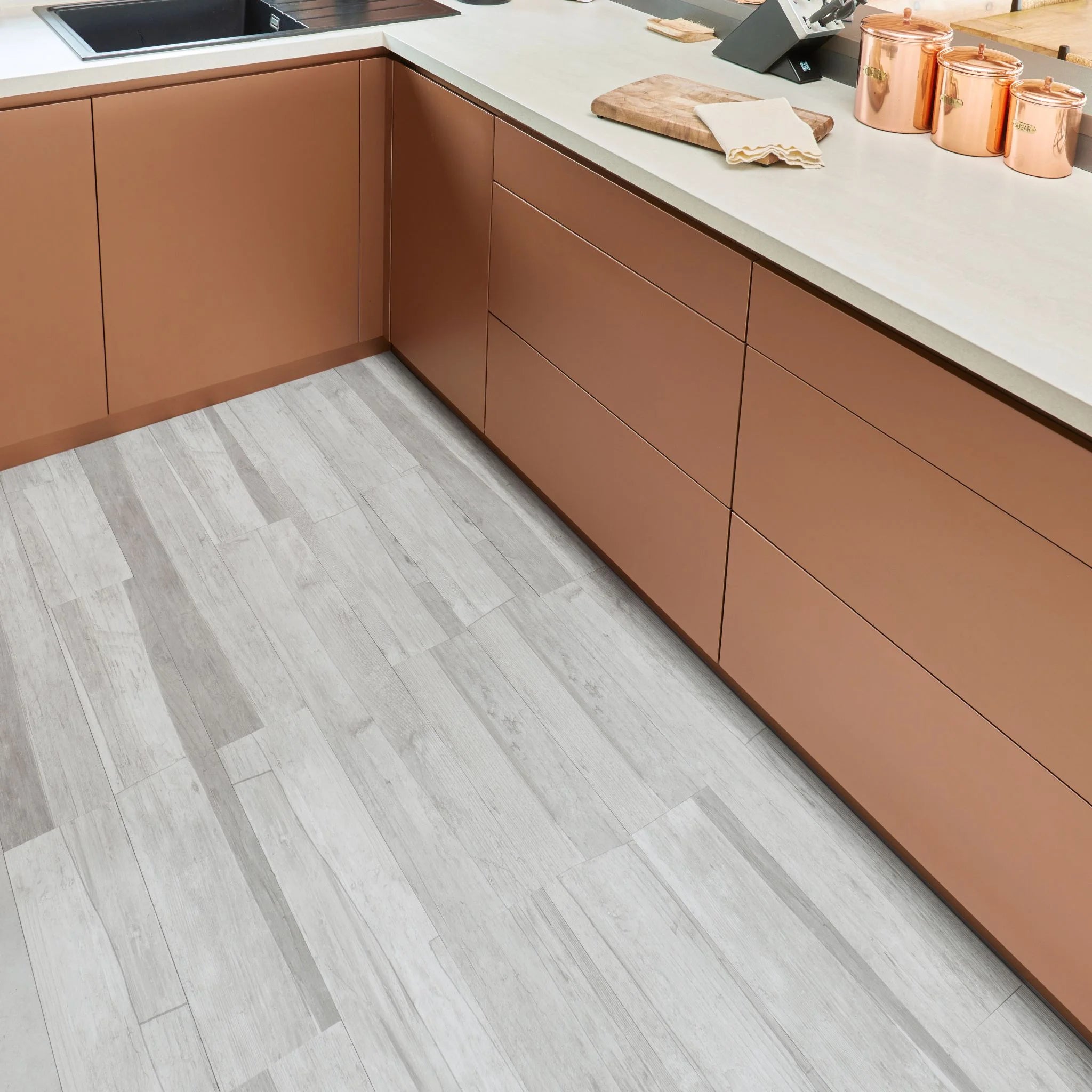 contemporary kitchen featuring brown kitchen furniture with greyscale marble flooring