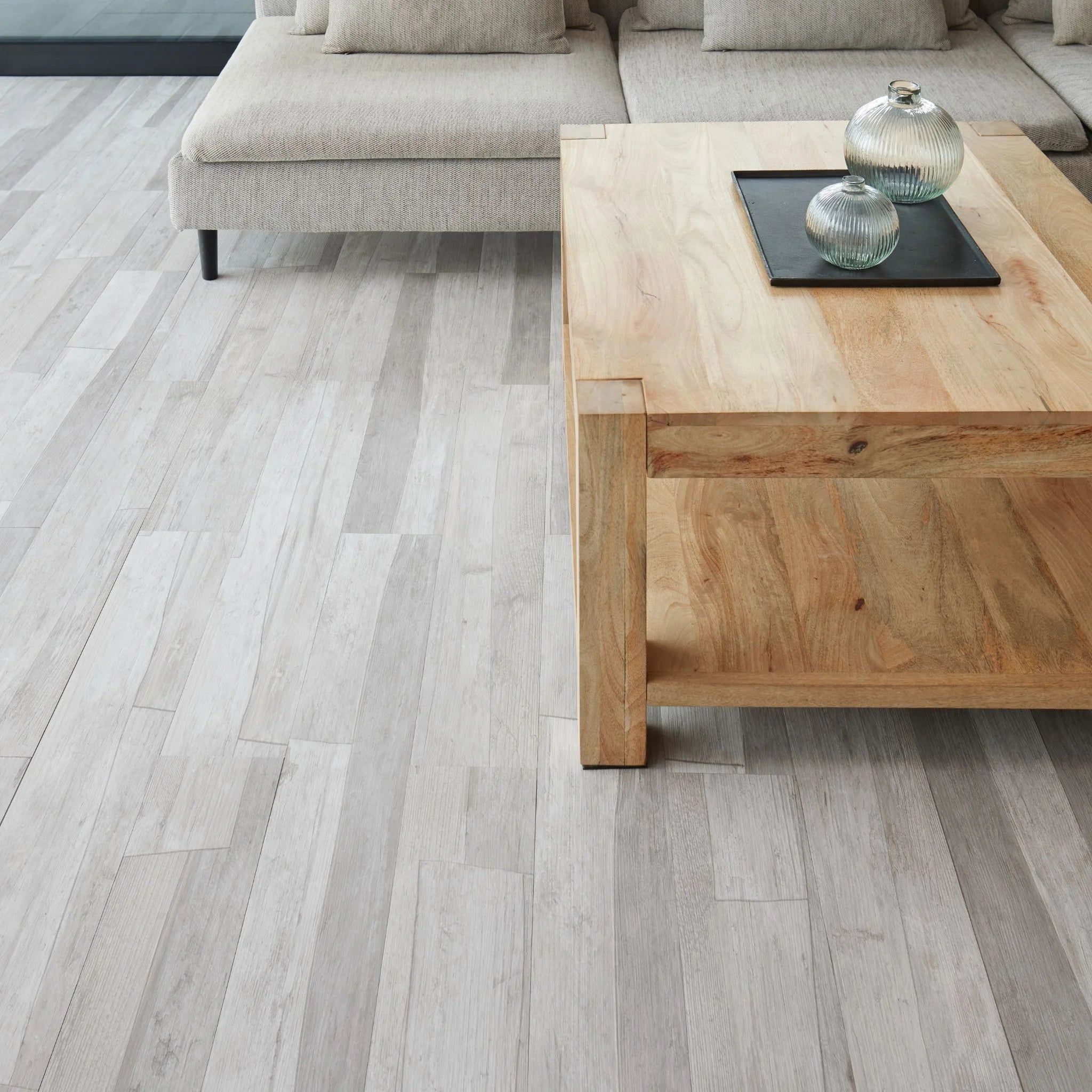 modern living room featuring grey sofa and light wood furniture on marble charcolar flooring