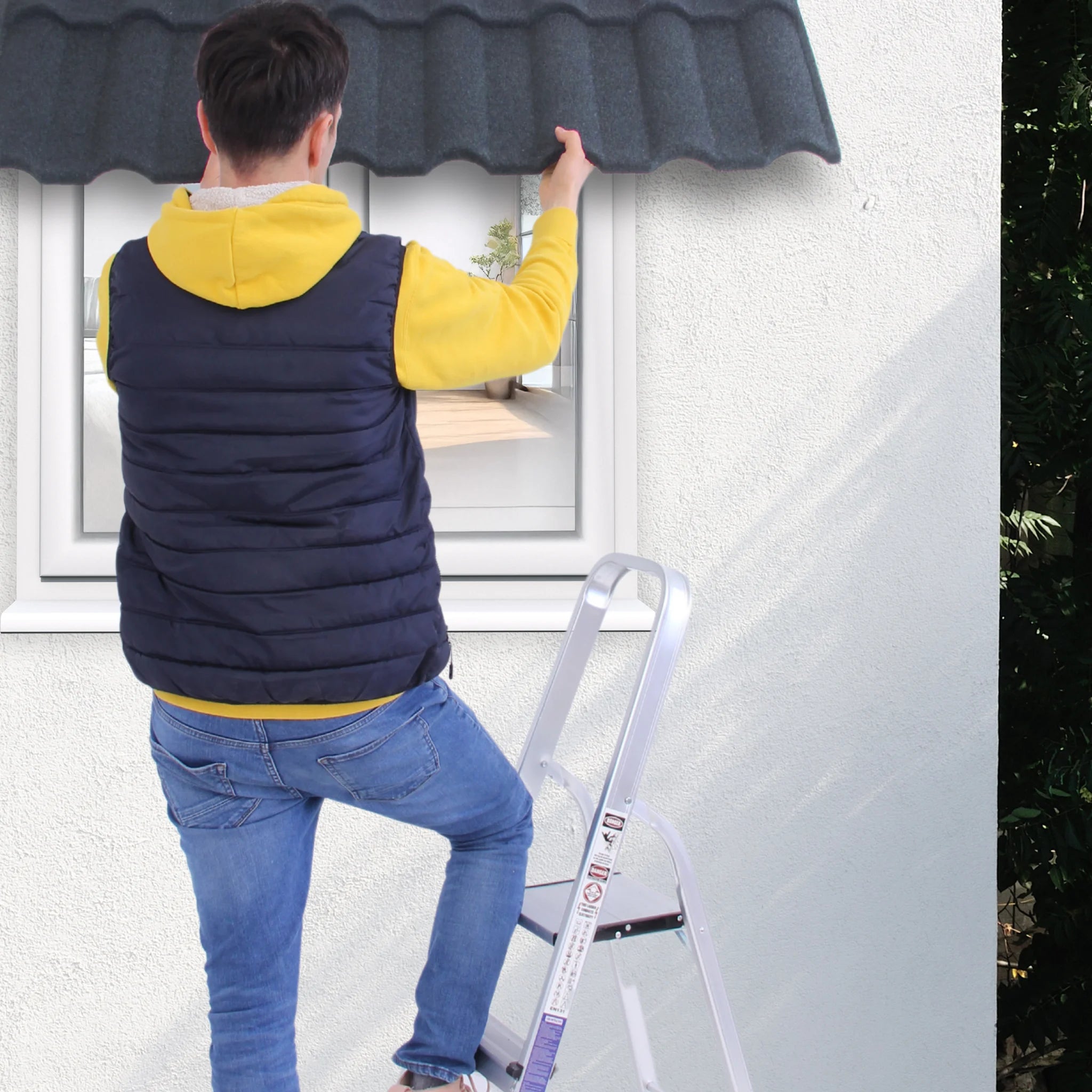 a man stands on a ladder, demonstrating corrugated roof tile application