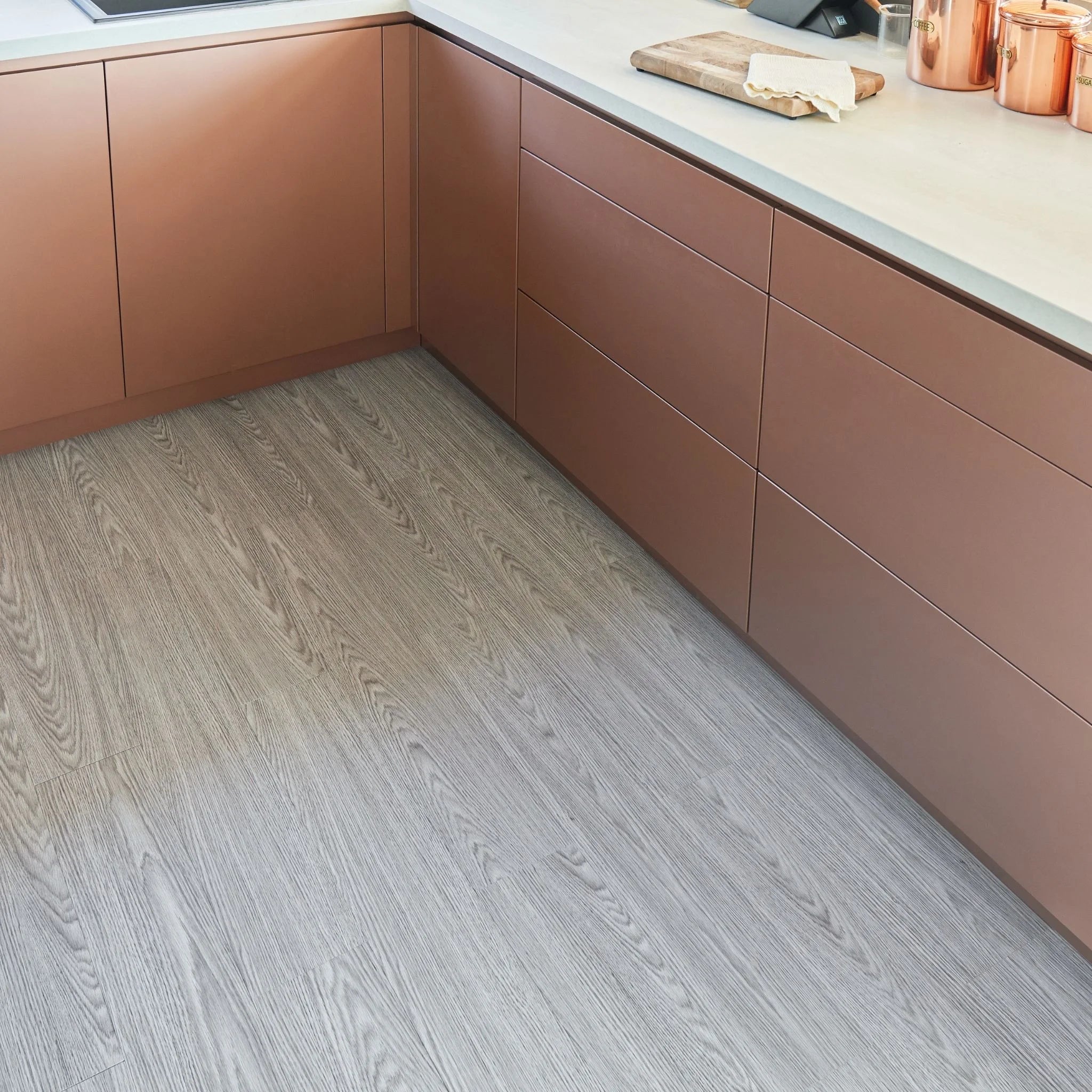 modern kitchen corner with brown cabinets and light grey wood-effect flooring