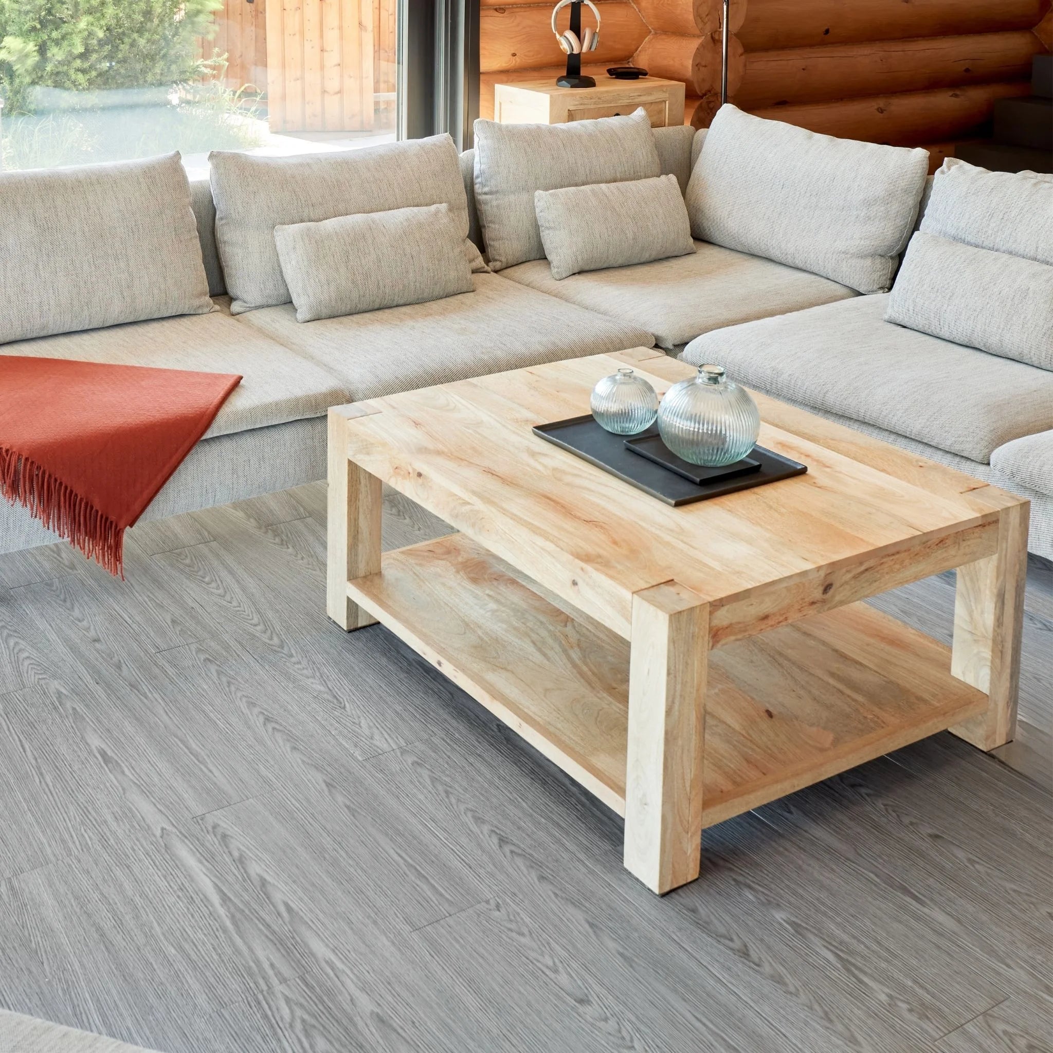 contemporary living room with large beige sofa, wooden coffee table, and light grey wood flooring