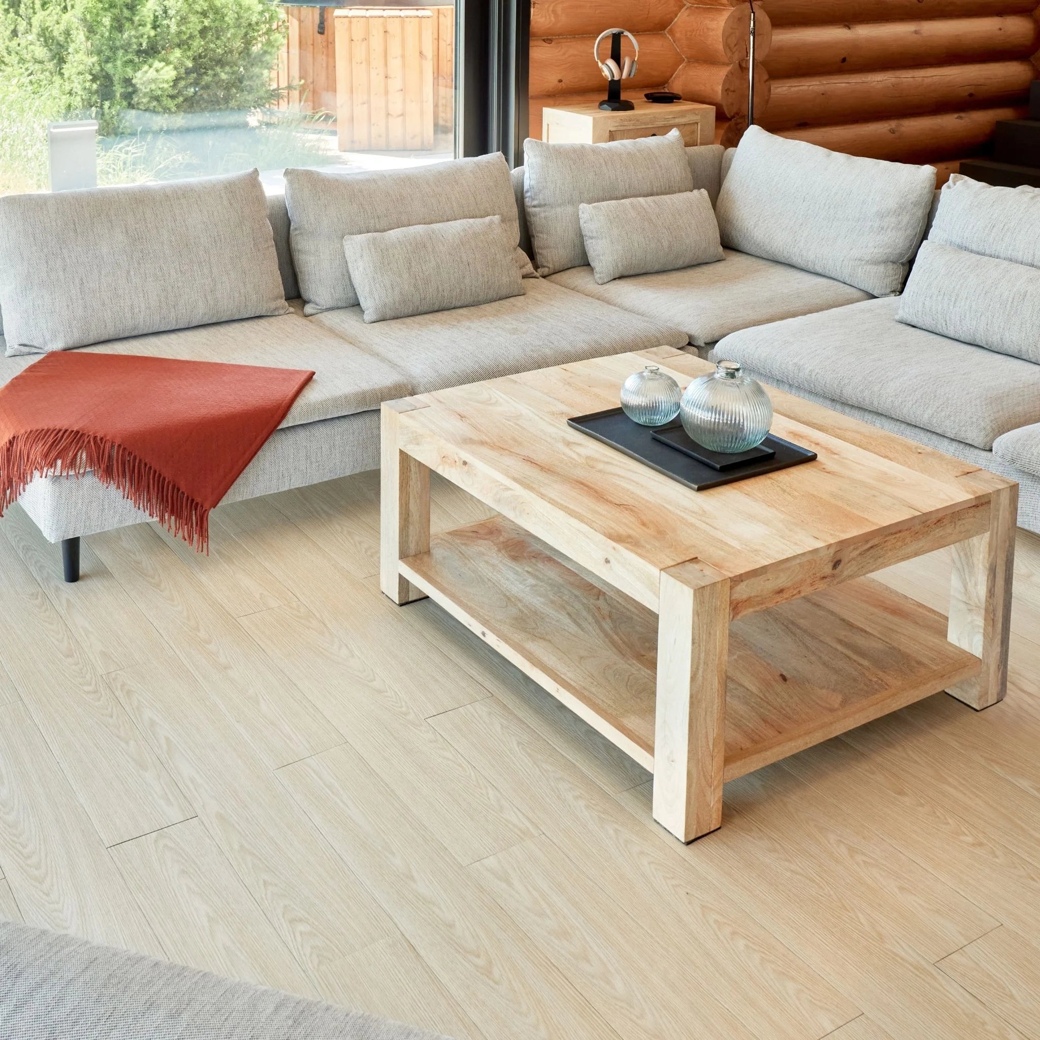 contemporary living room with large beige sofa, wooden coffee table, and natural beige wood flooring