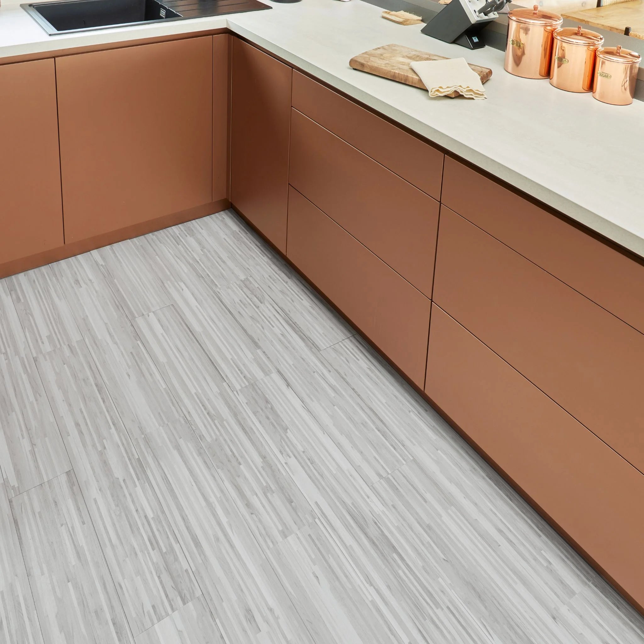 contemporary kitchen featuring brown kitchen furniture with grey flooring