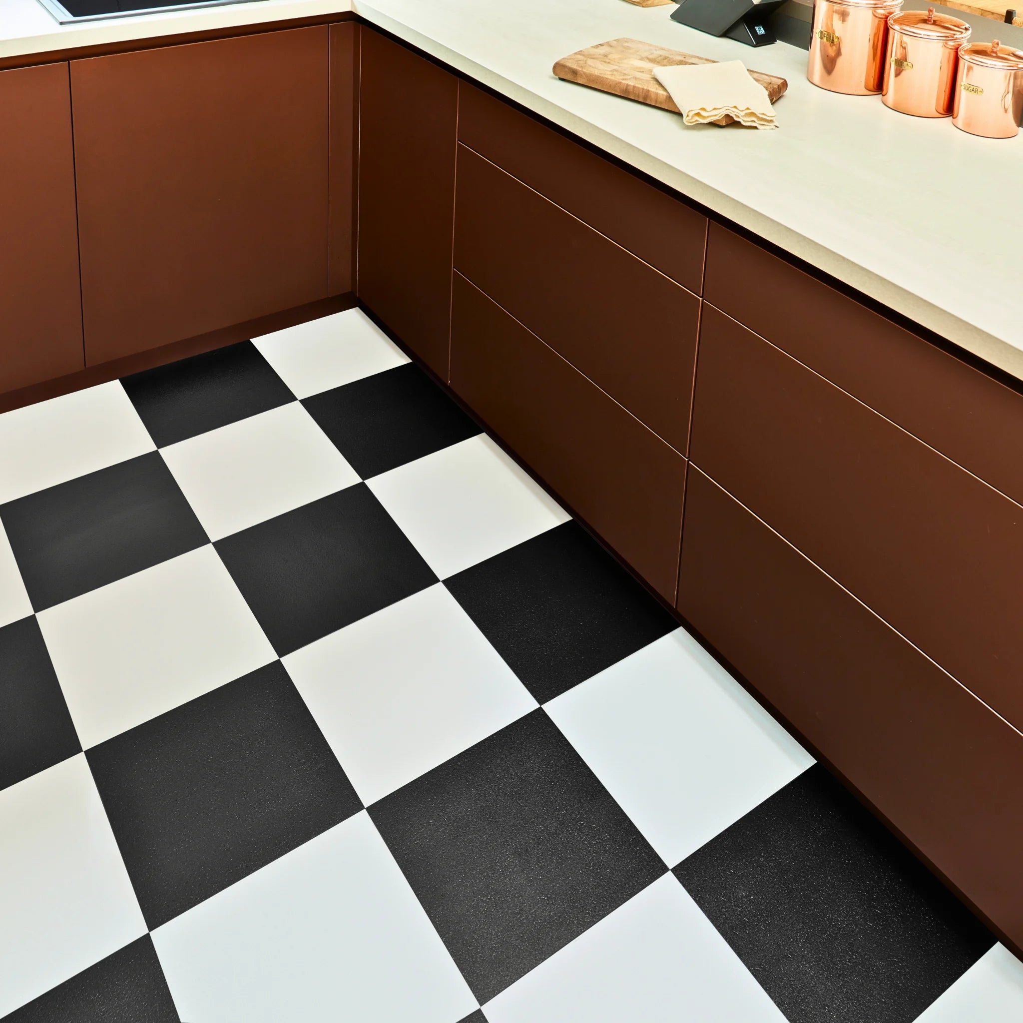 contemporary kitchen featuring brown kitchen furniture with black and white flooring
