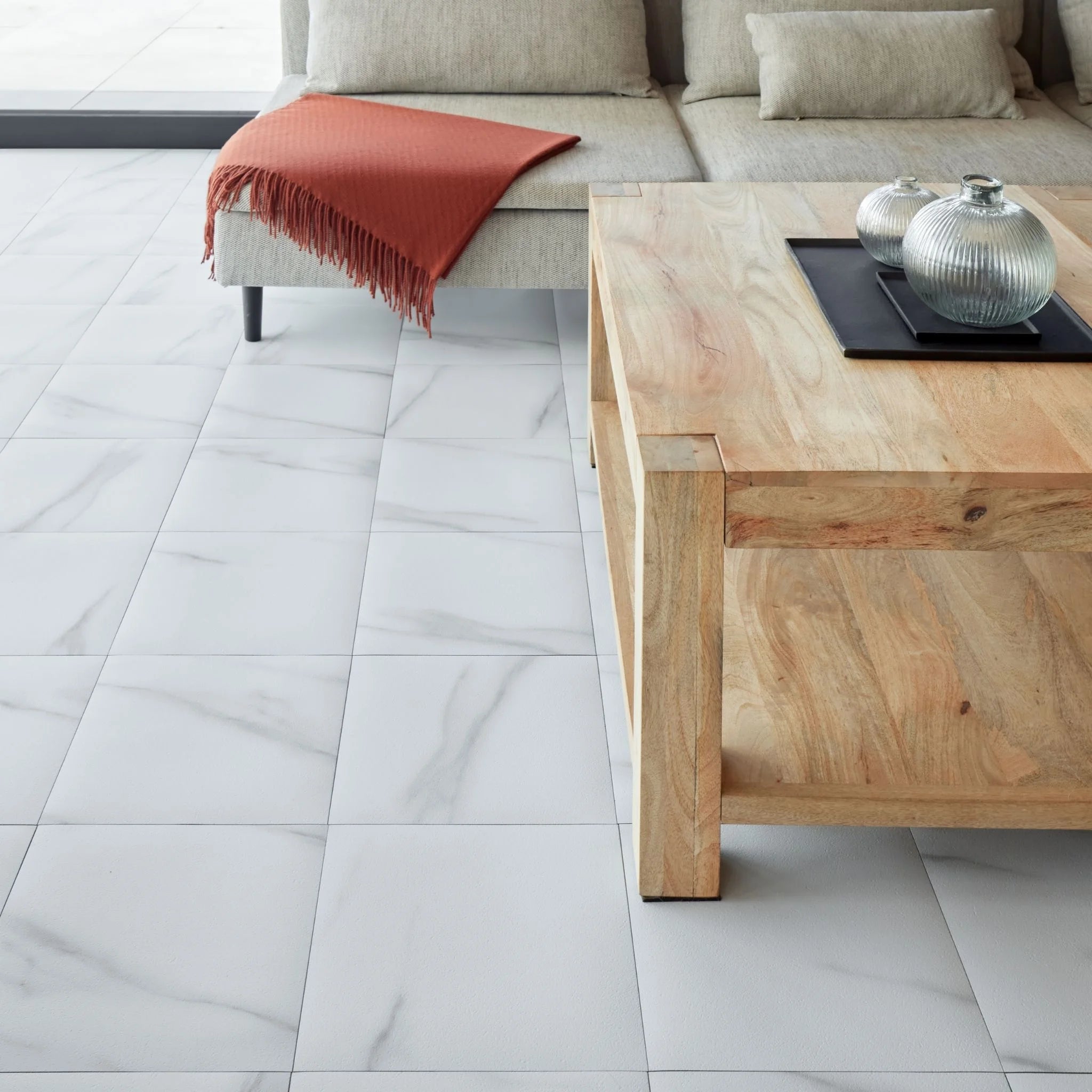 spacious living room with rustic furniture and white tile-effect concrete flooring