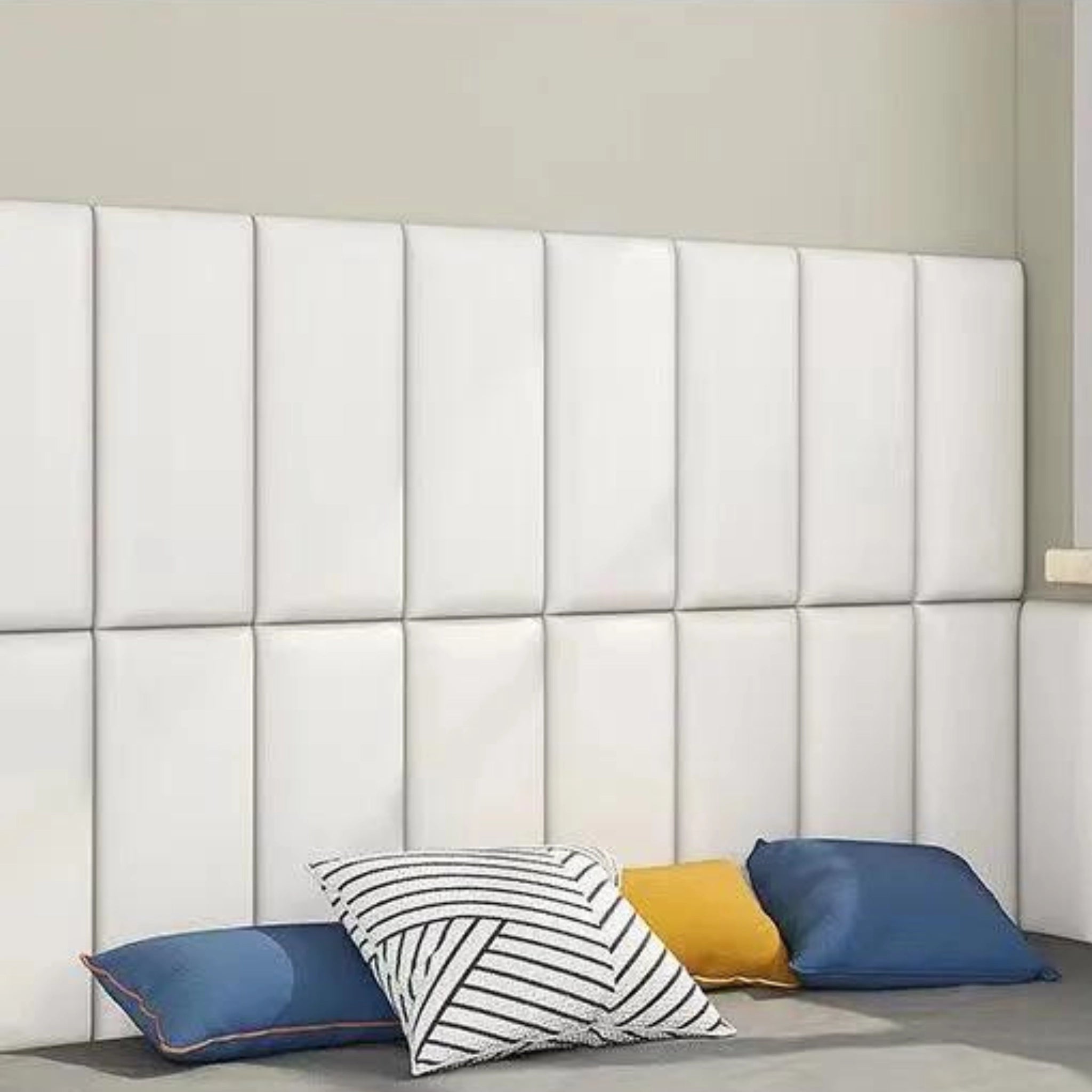 Modern bedroom with white upholstered wall panel featuring padded surface