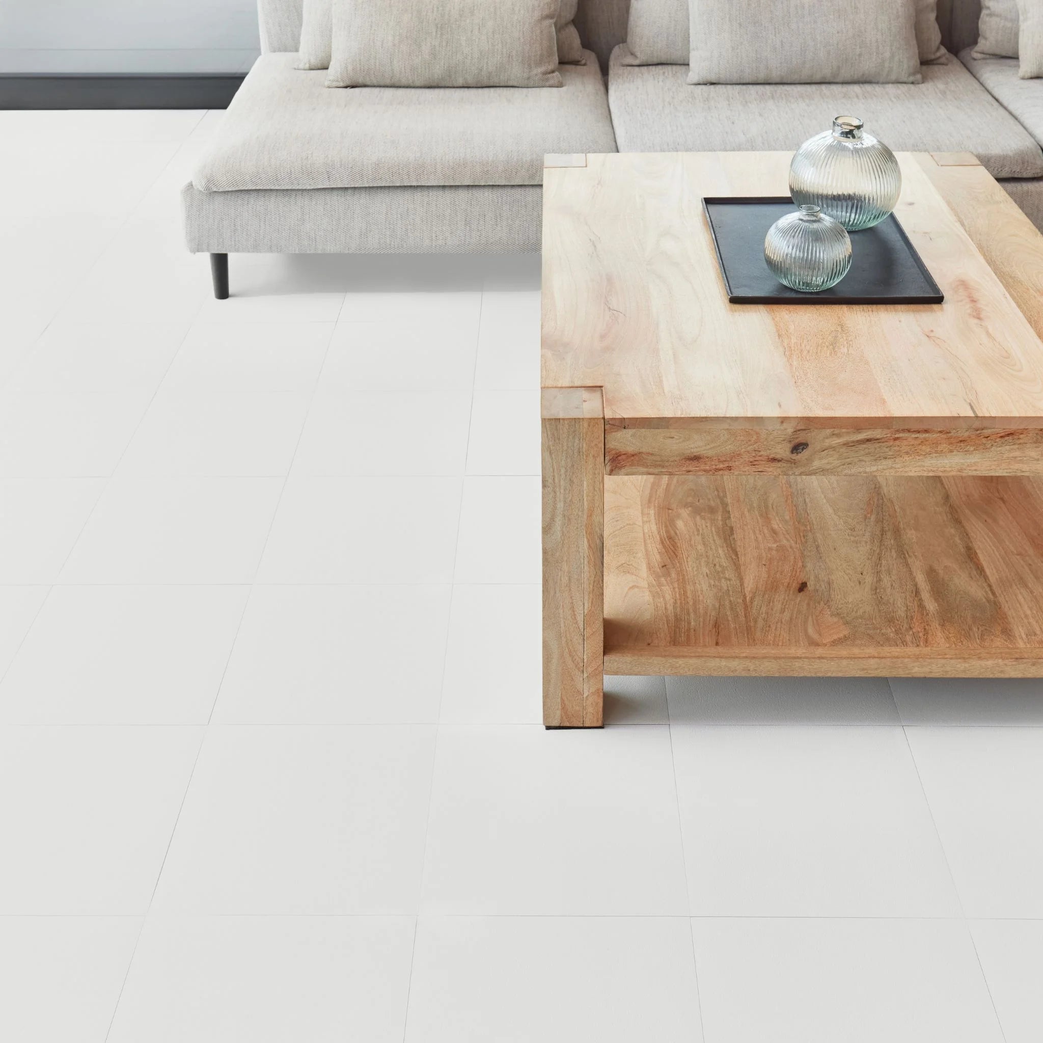 modern living room featuring grey sofa and light wood furniture on white flooring