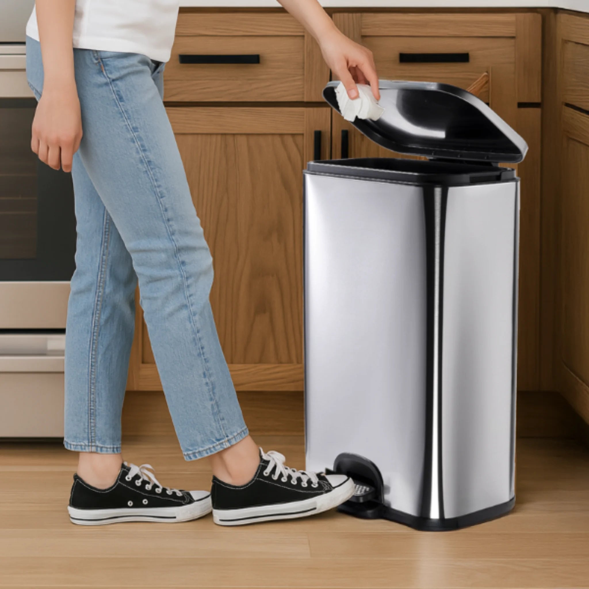 A woman positions a 50L kitchen bin with lid ready to dispose of waste