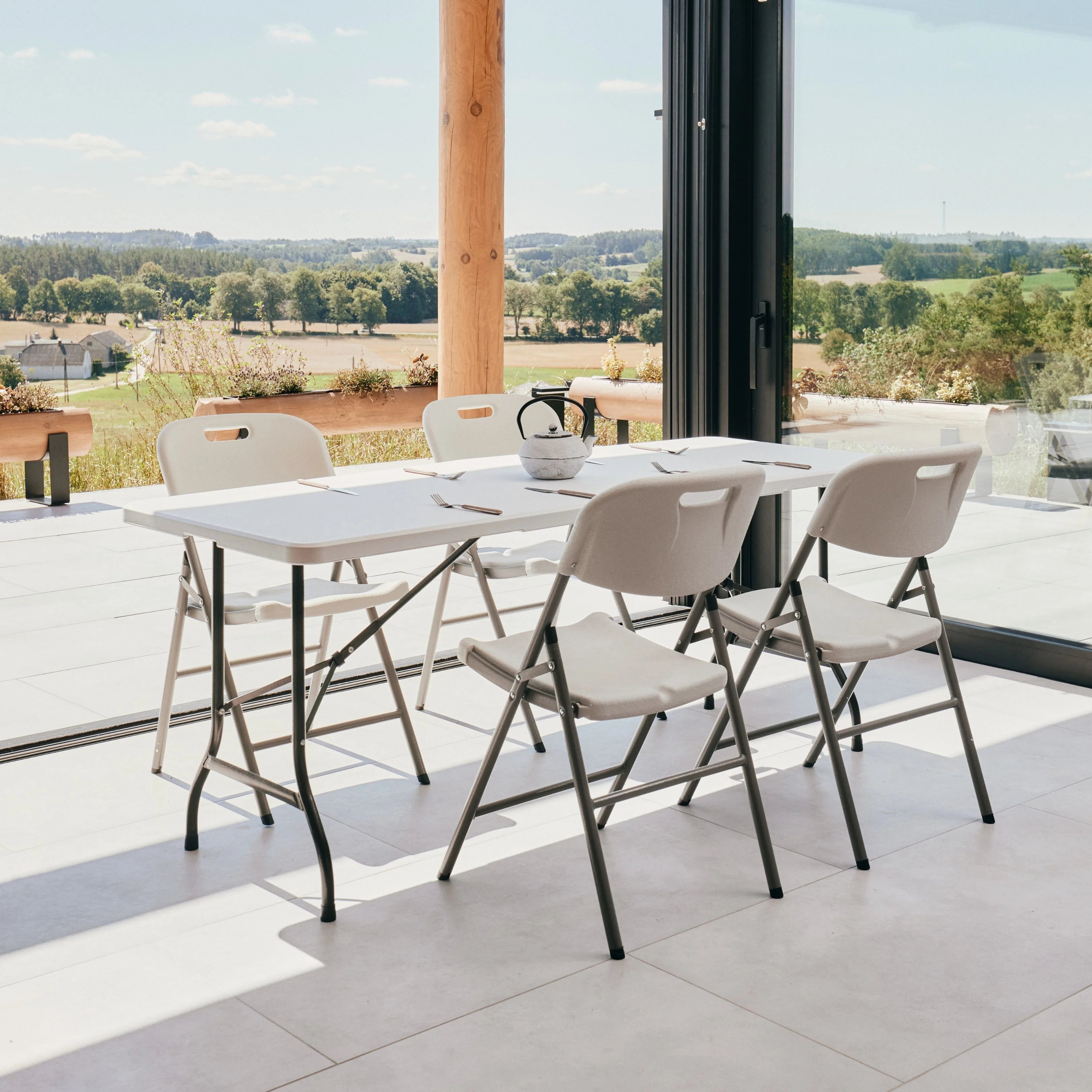 white 6ft folding table and chair on patio with scenic view