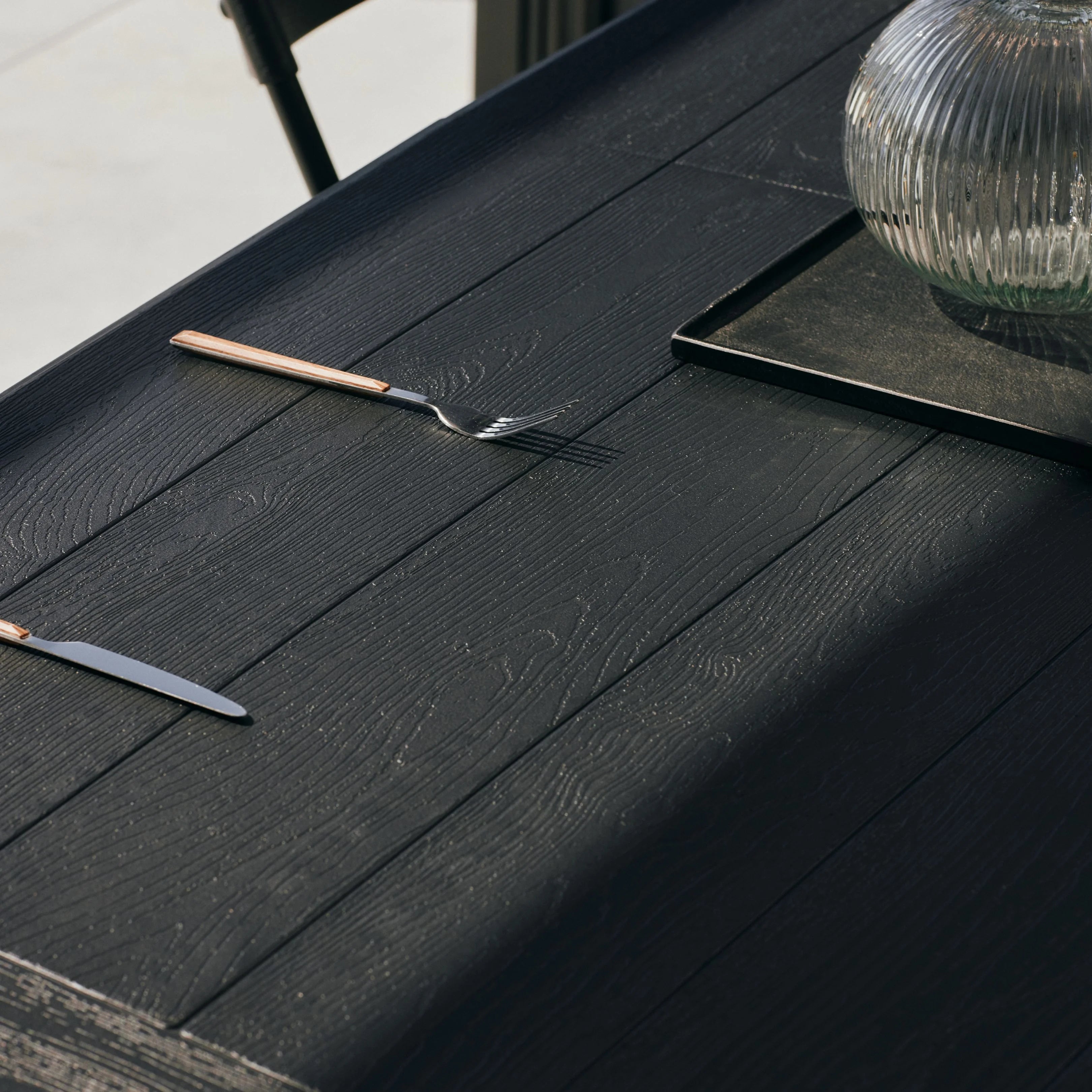 close up of black 6ft table and bench with utensils on top