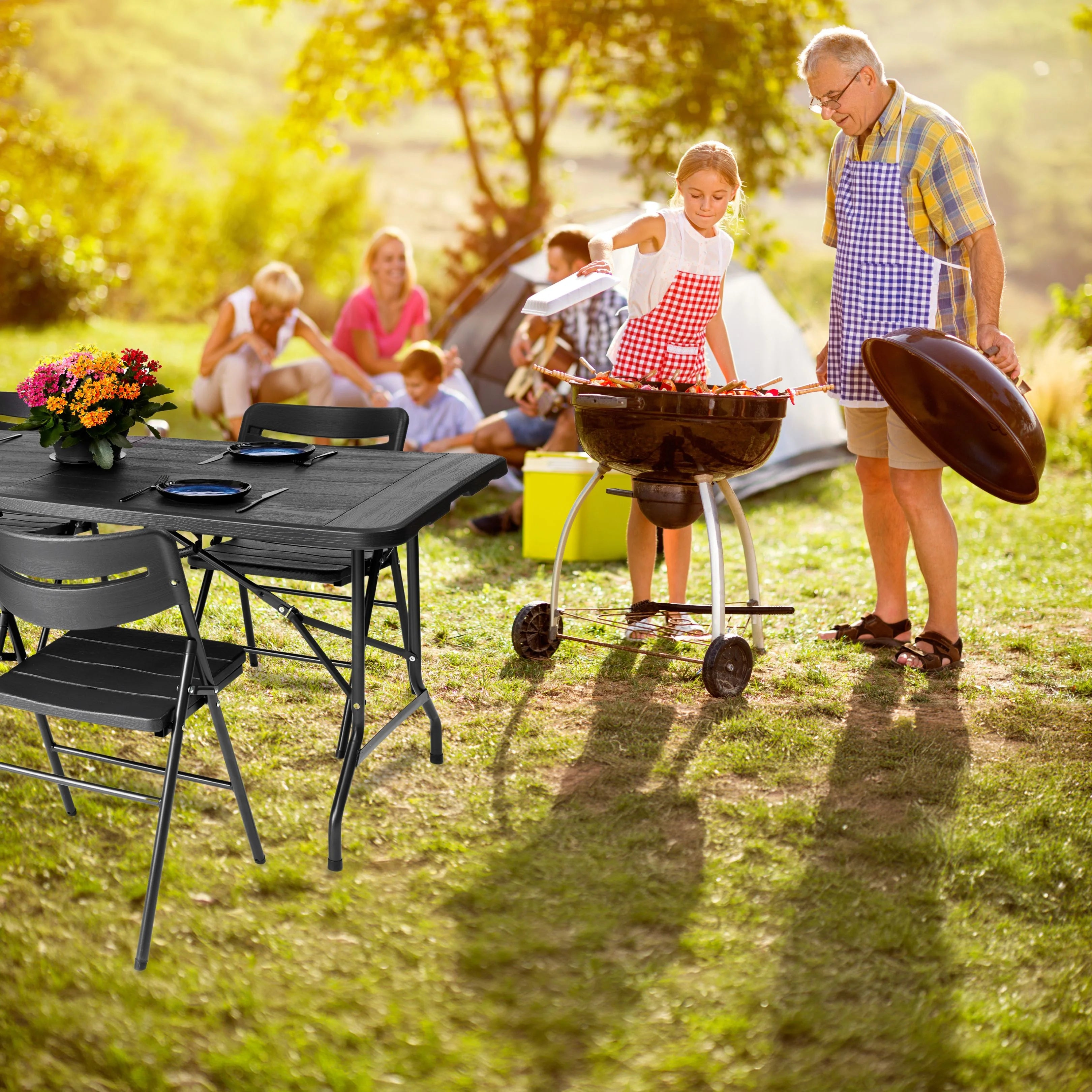 black 6ft folding table and chairs in use at outdoor barbecue