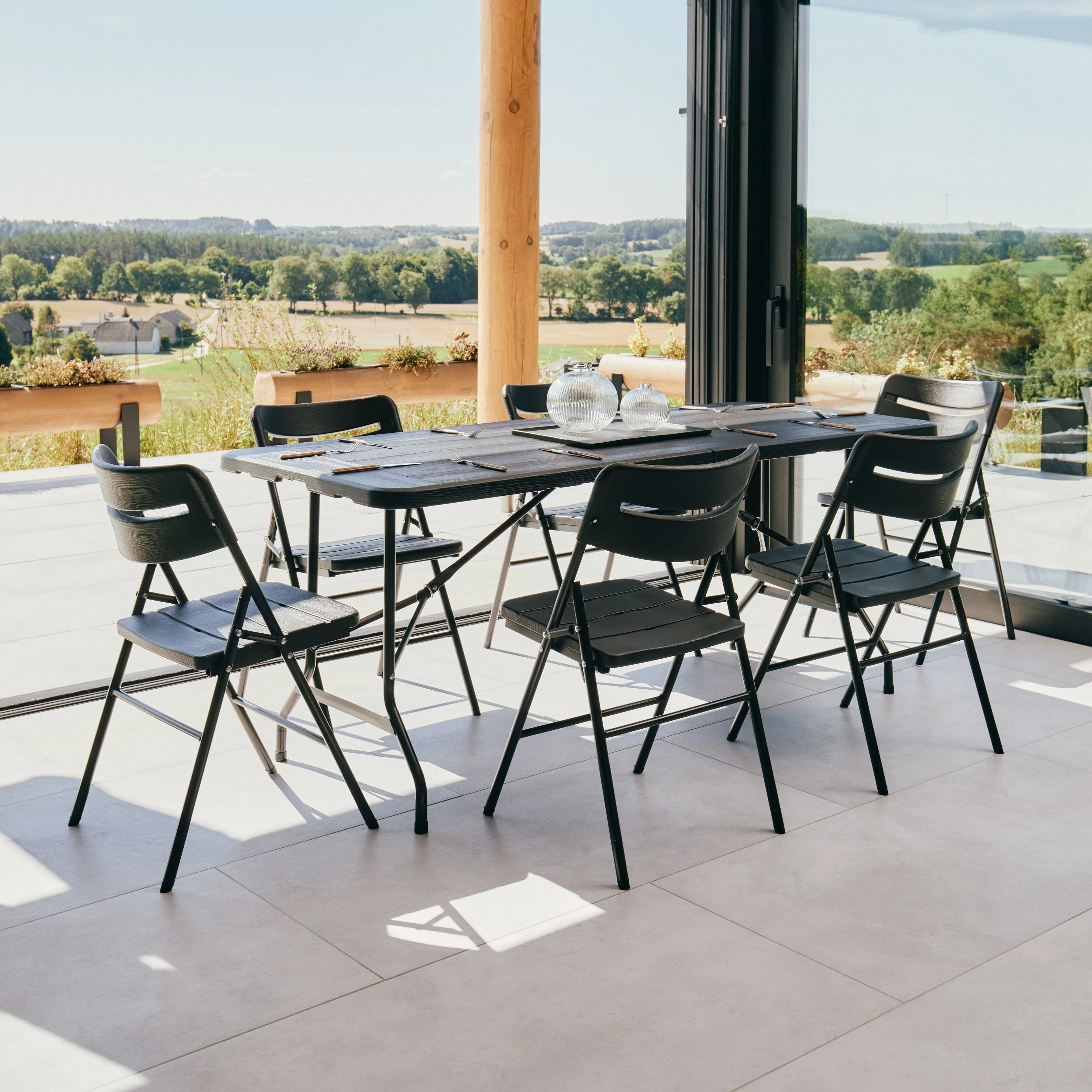 black 6ft folding table and chair on patio with scenic view