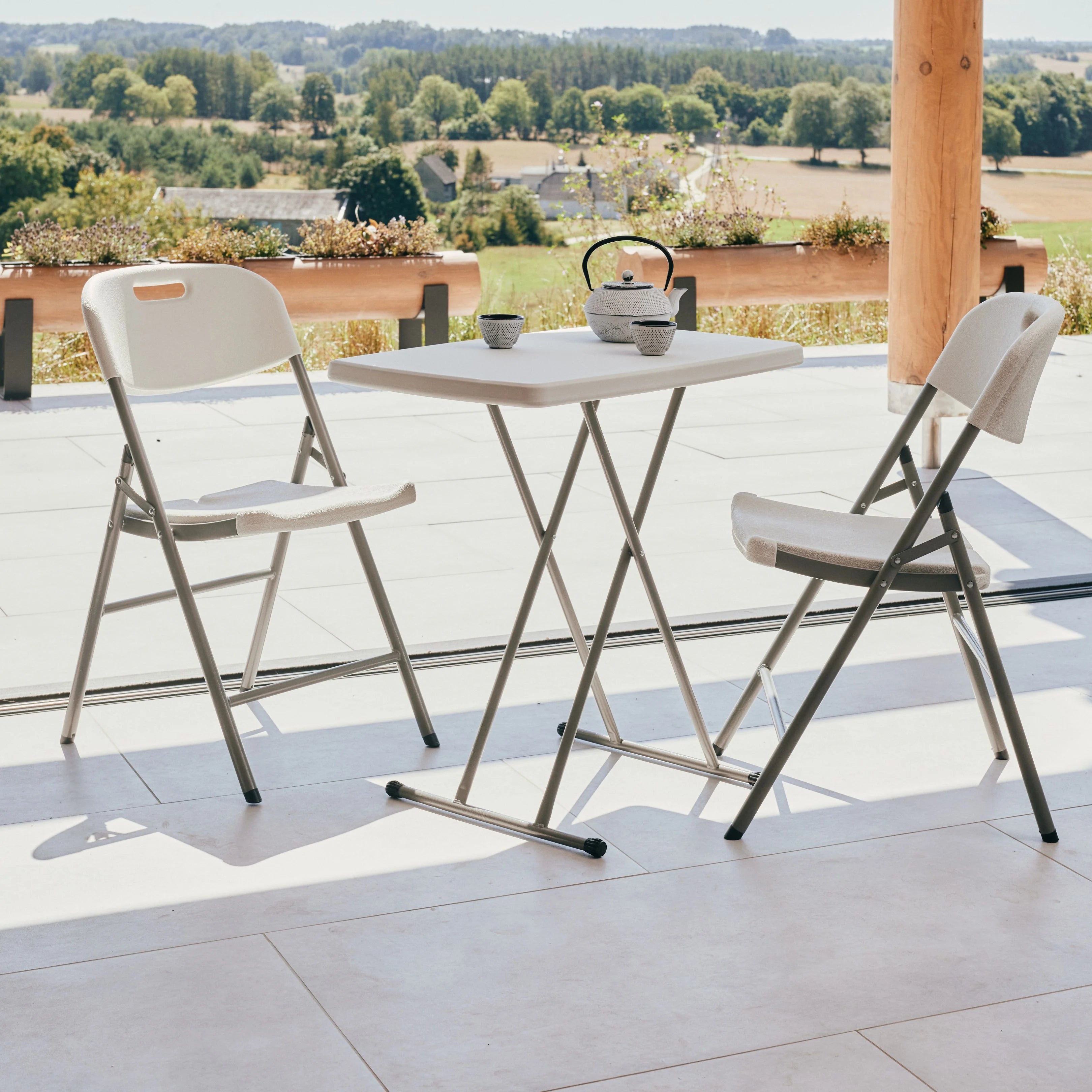 white rectangular folding table and chair on patio with teapot