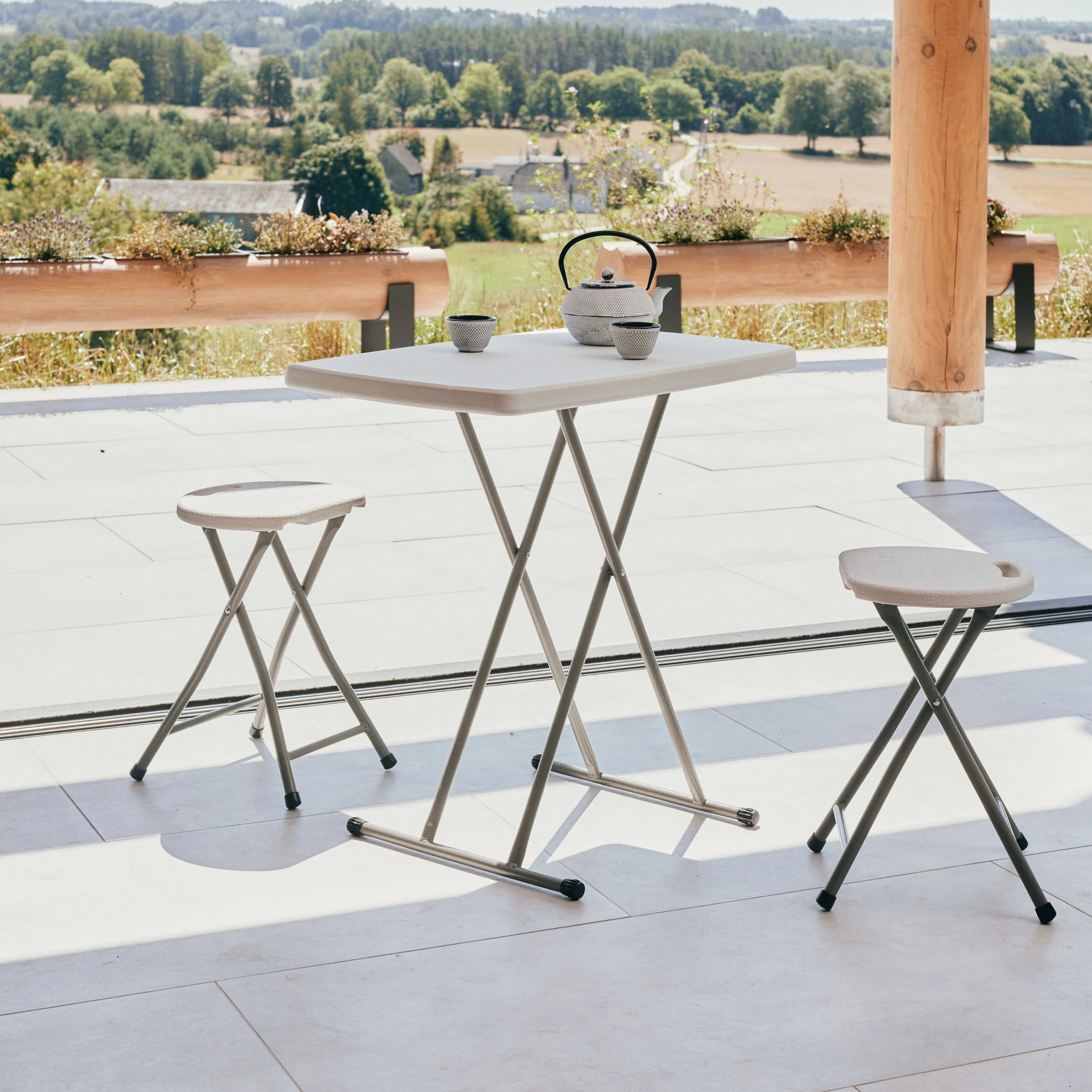 white rectangular folding table and stool on patio with teapot