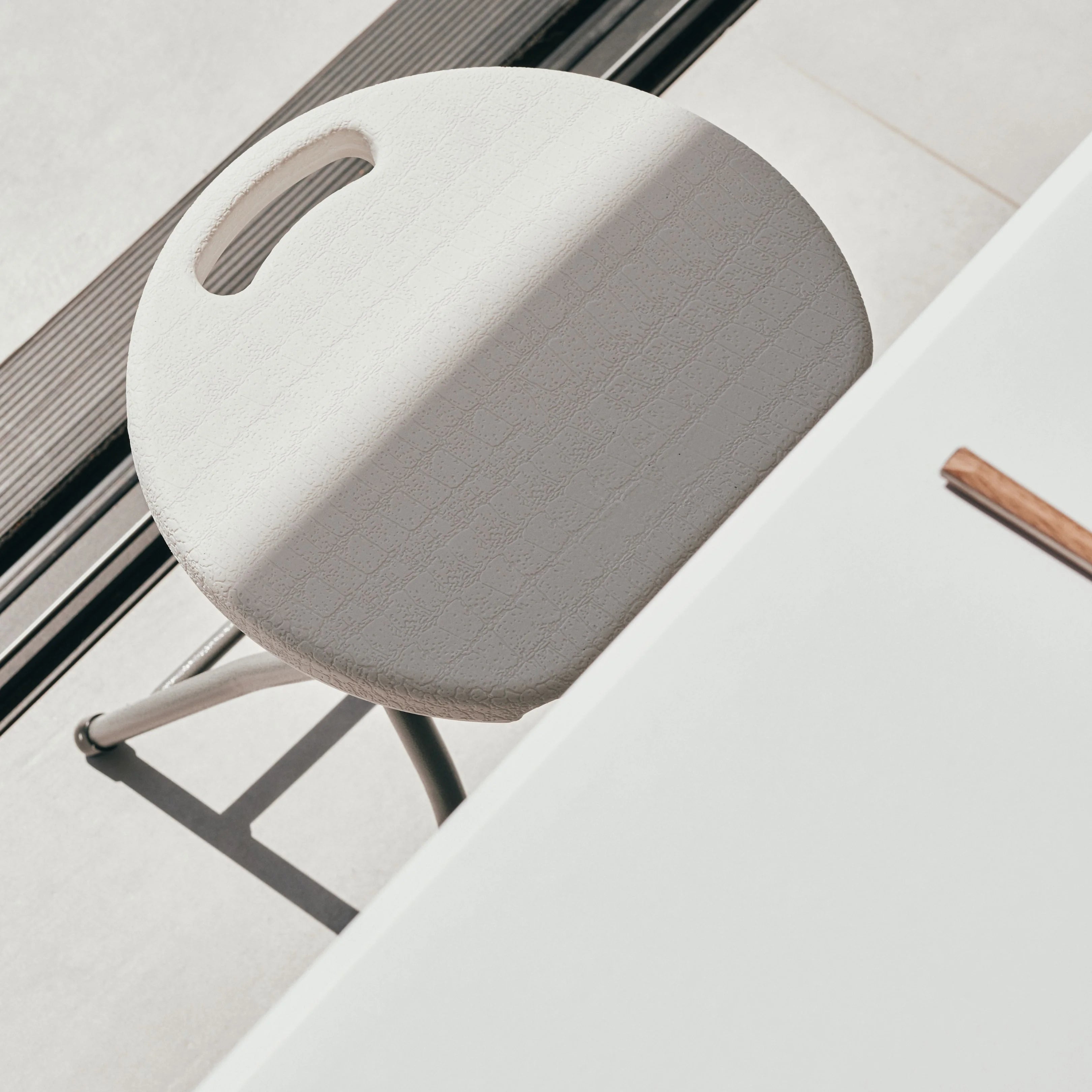 close up of white rectangular table and stool corner detail