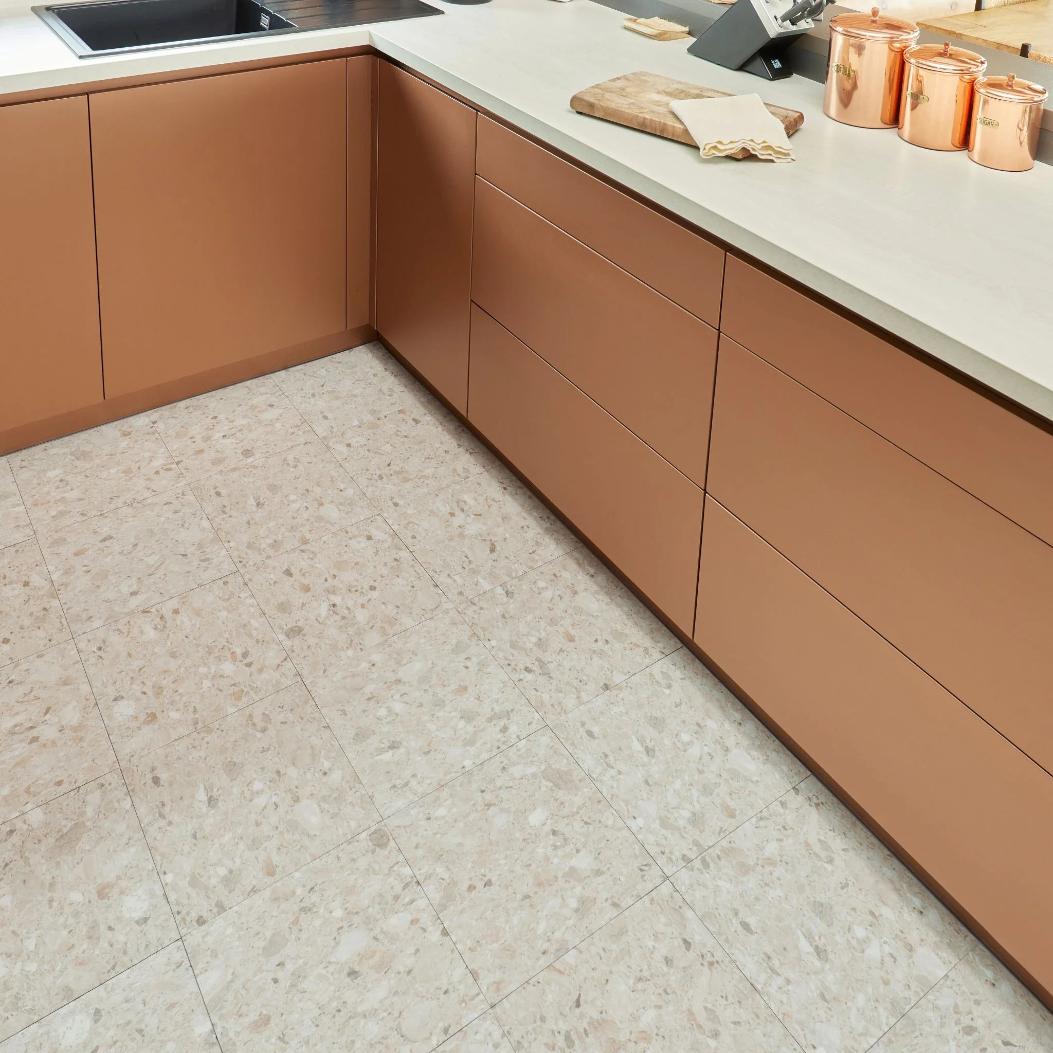 contemporary kitchen featuring brown kitchen furniture with desert terrazzo flooring