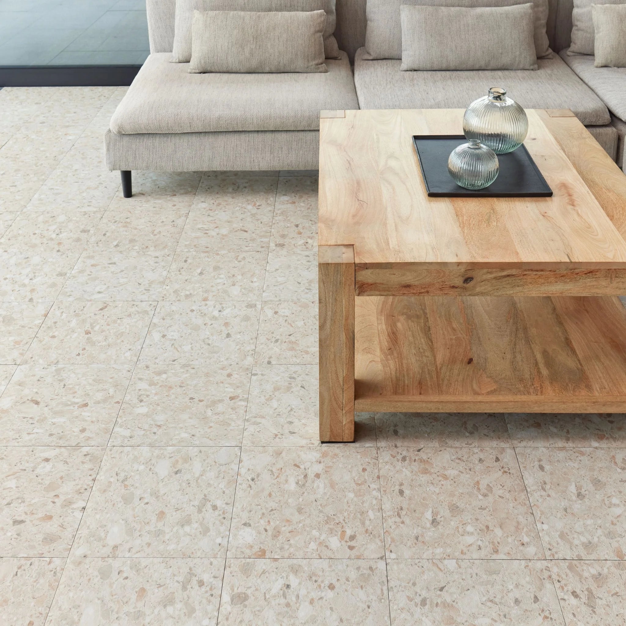 modern living room featuring grey sofa and light wood furniture on desert terrazzo flooring