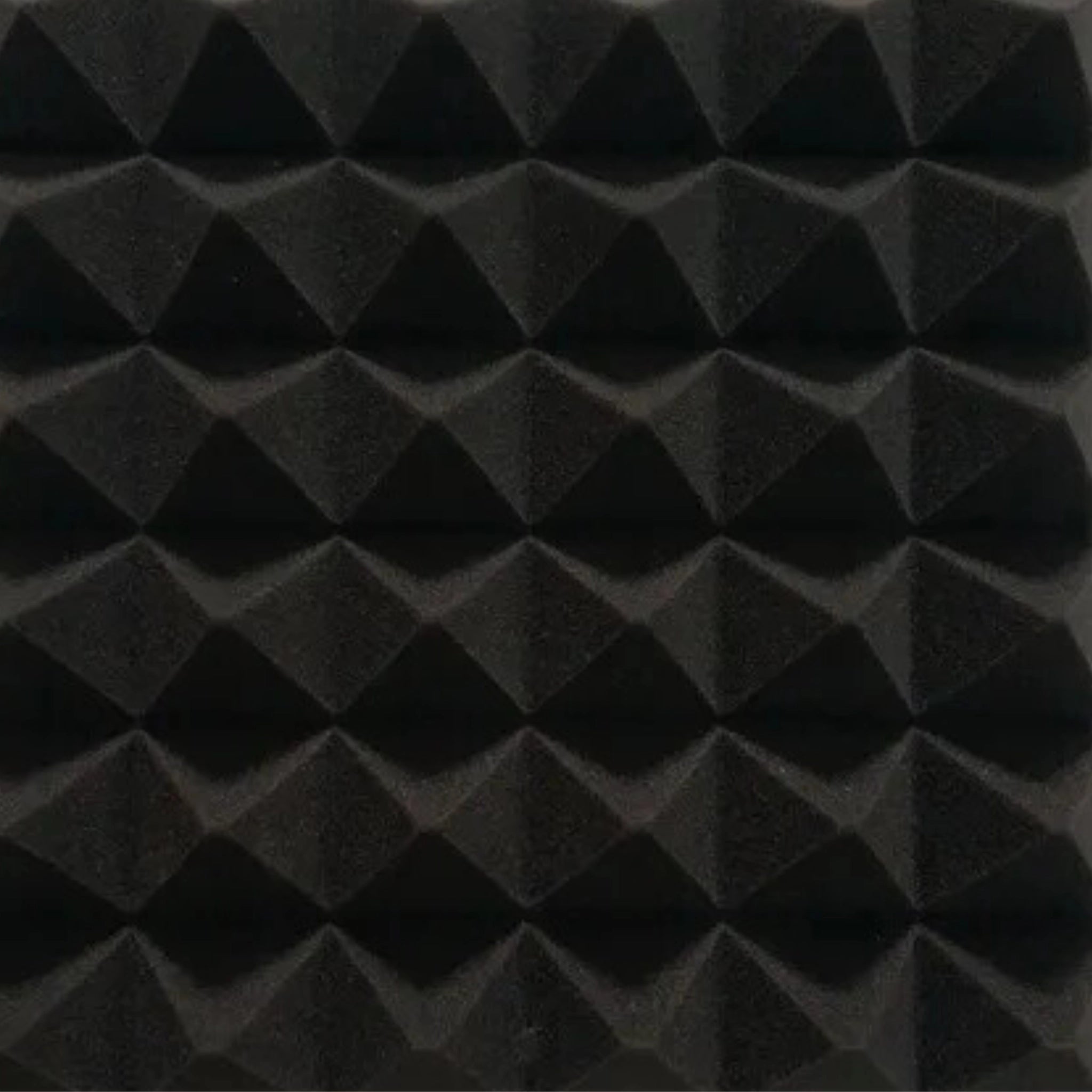 Close-up of black acoustic foam panel with pyramid texture