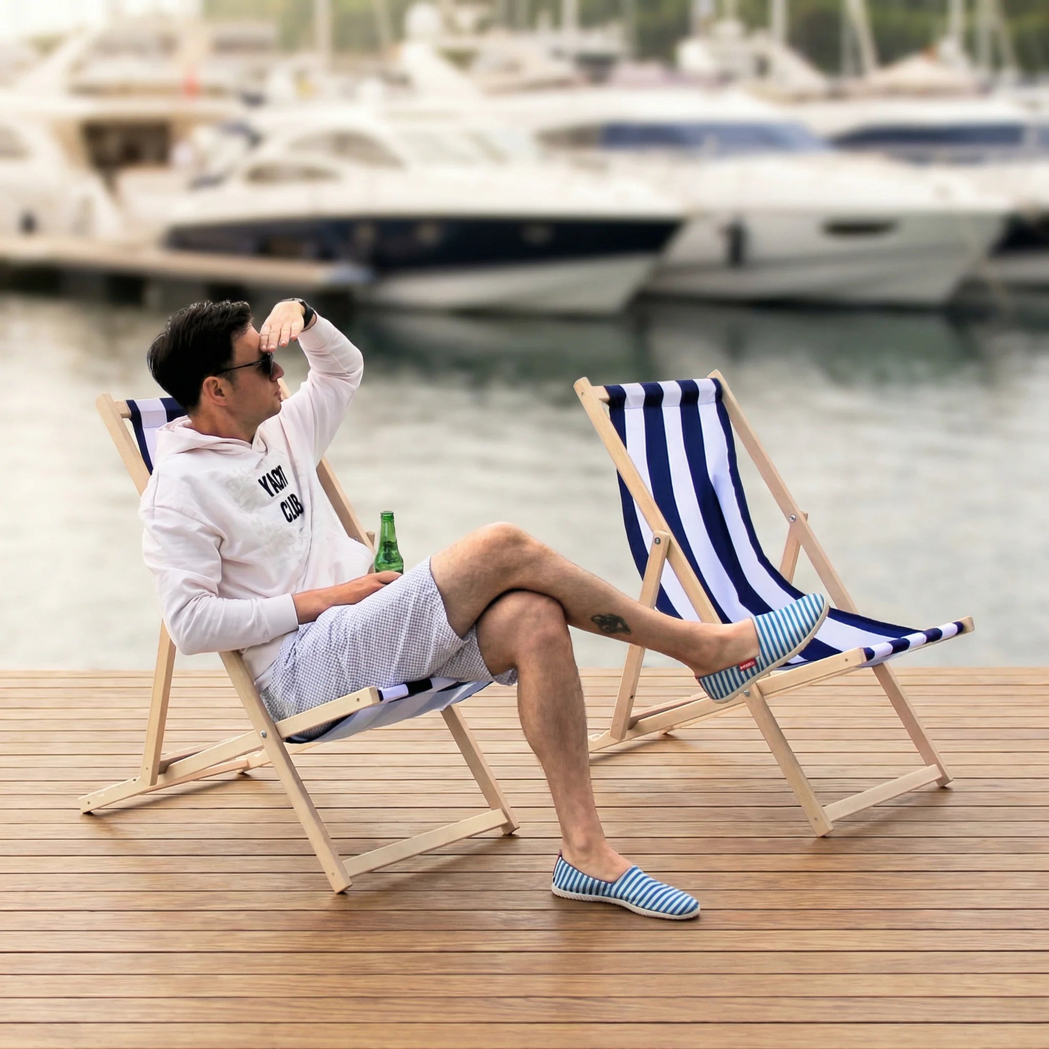 Man relaxing on wooden decking chai