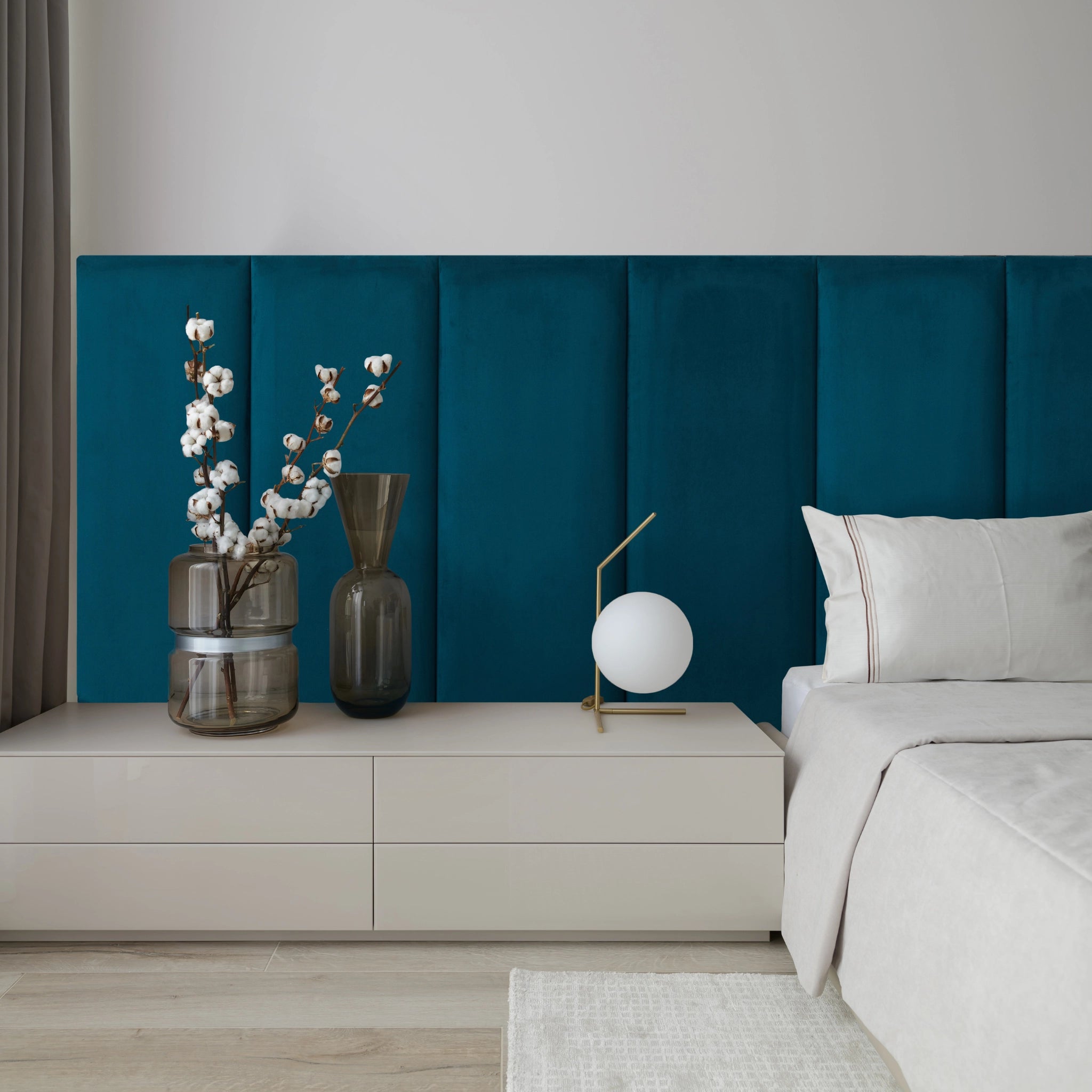 Modern bedroom with blue upholstered wall panel featuring padded surface 