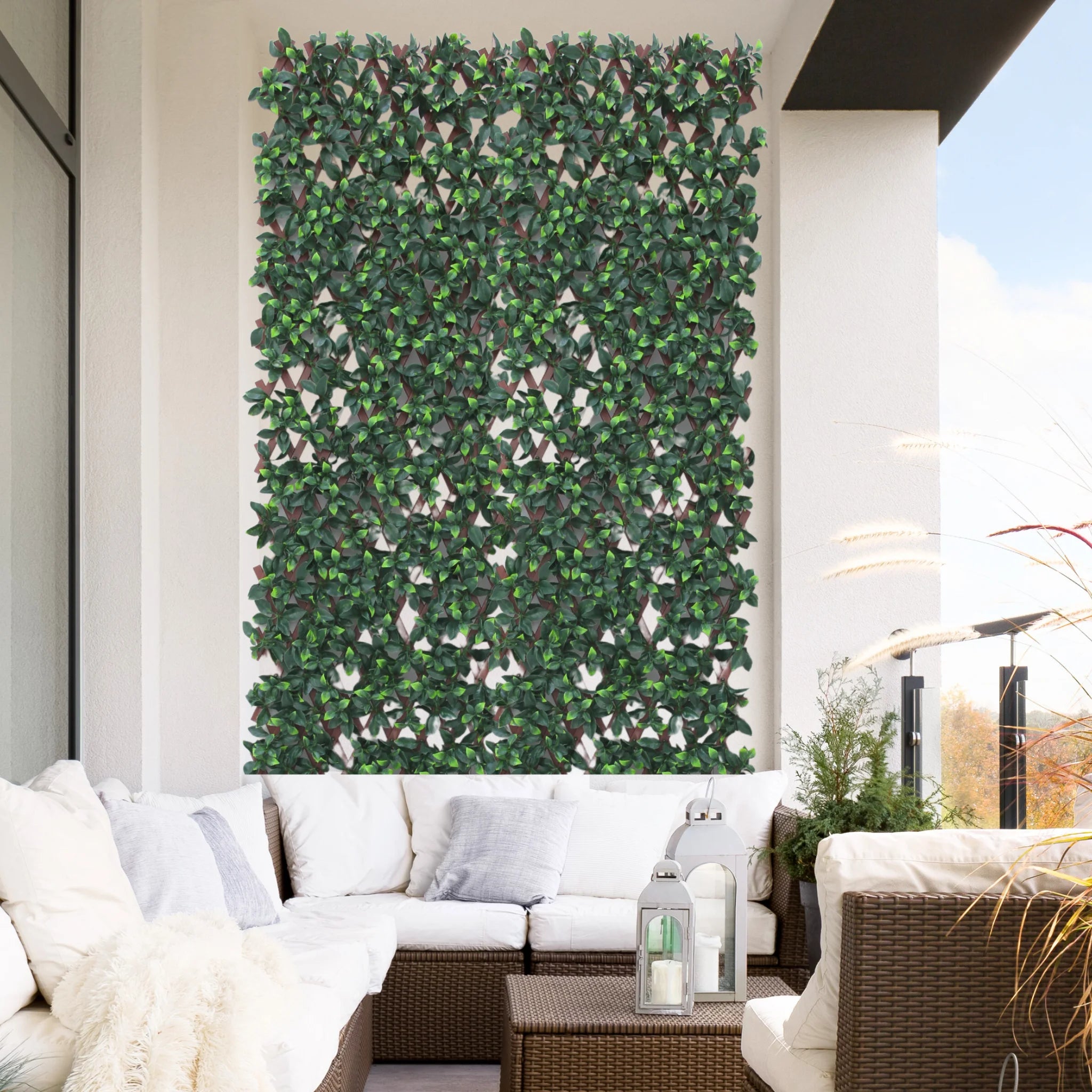 expanding trellis with artificial leaves white flowers on balcony wall