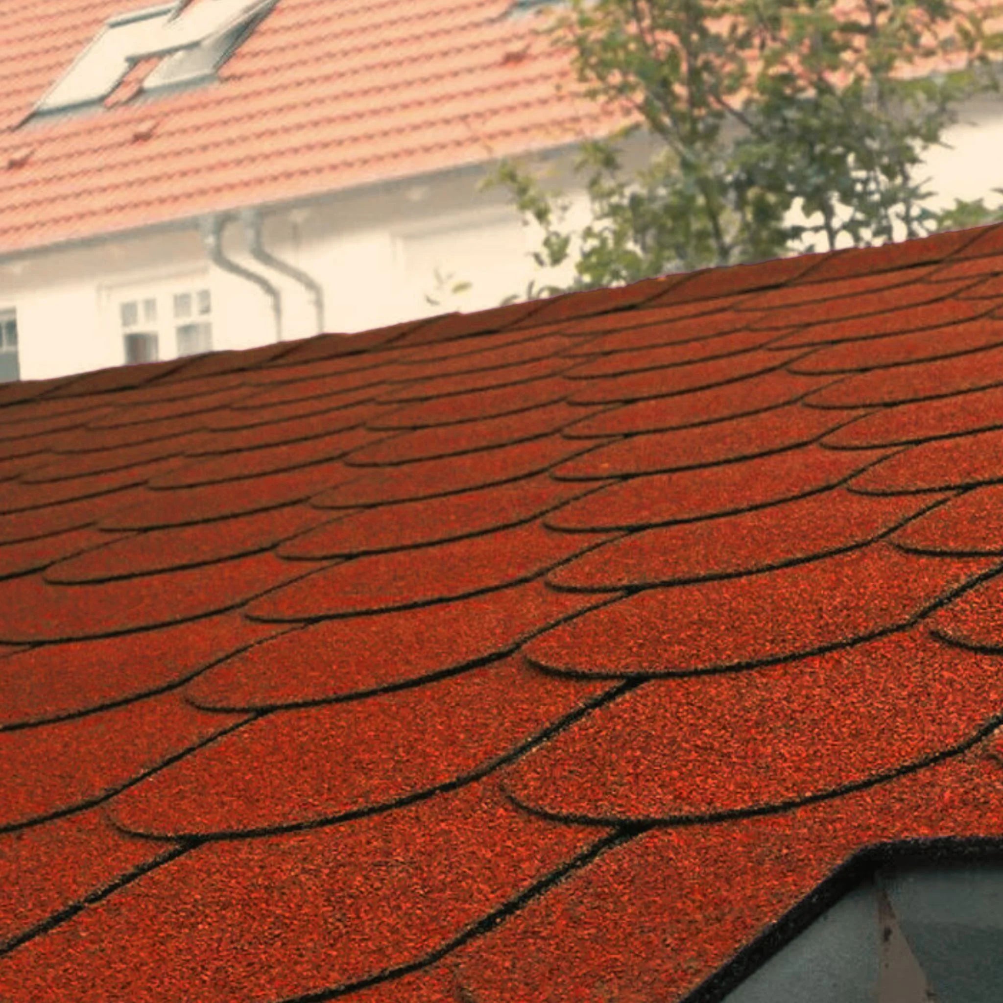 roof with installed red fish scales shape shingles against blue sky