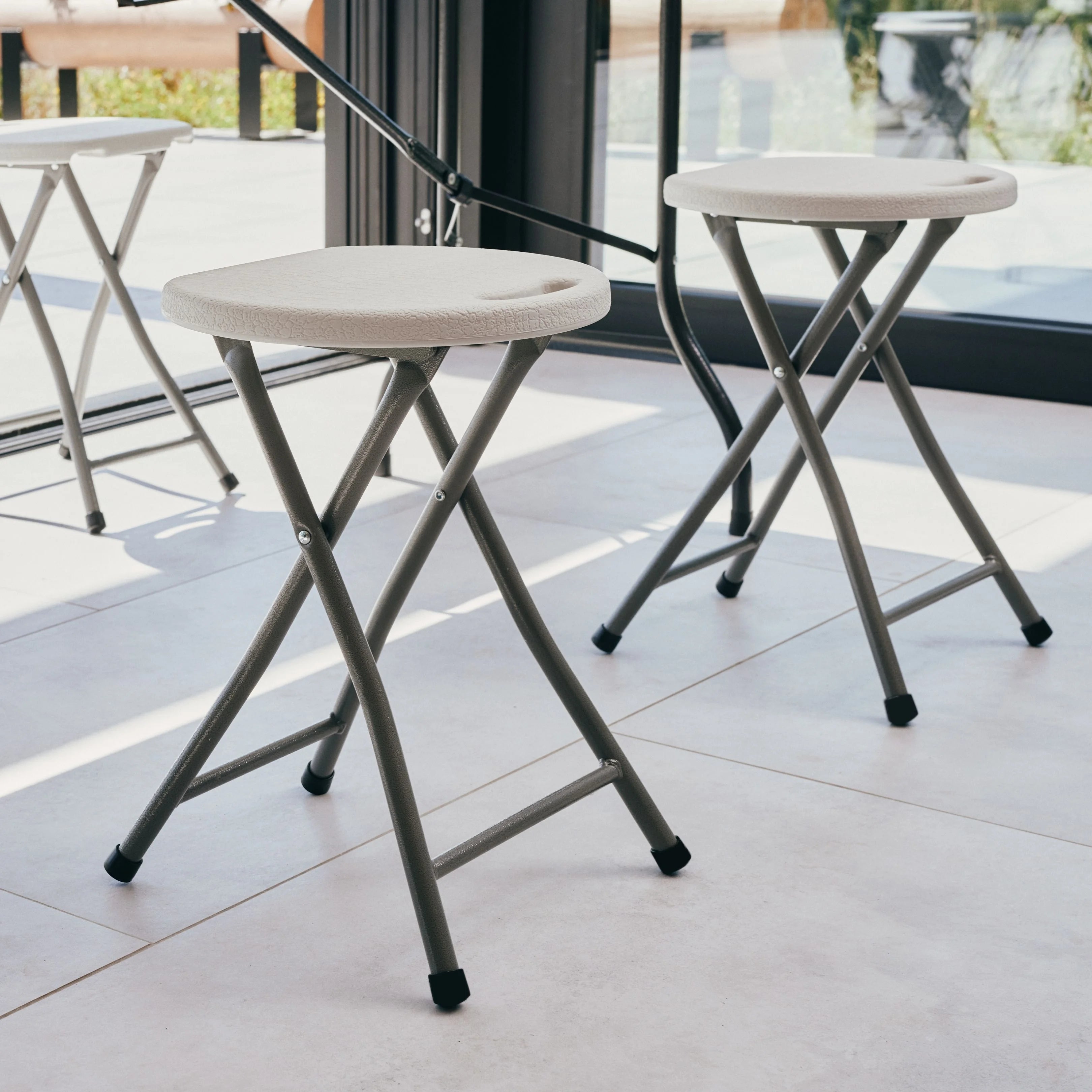 white folding stool on a patio 