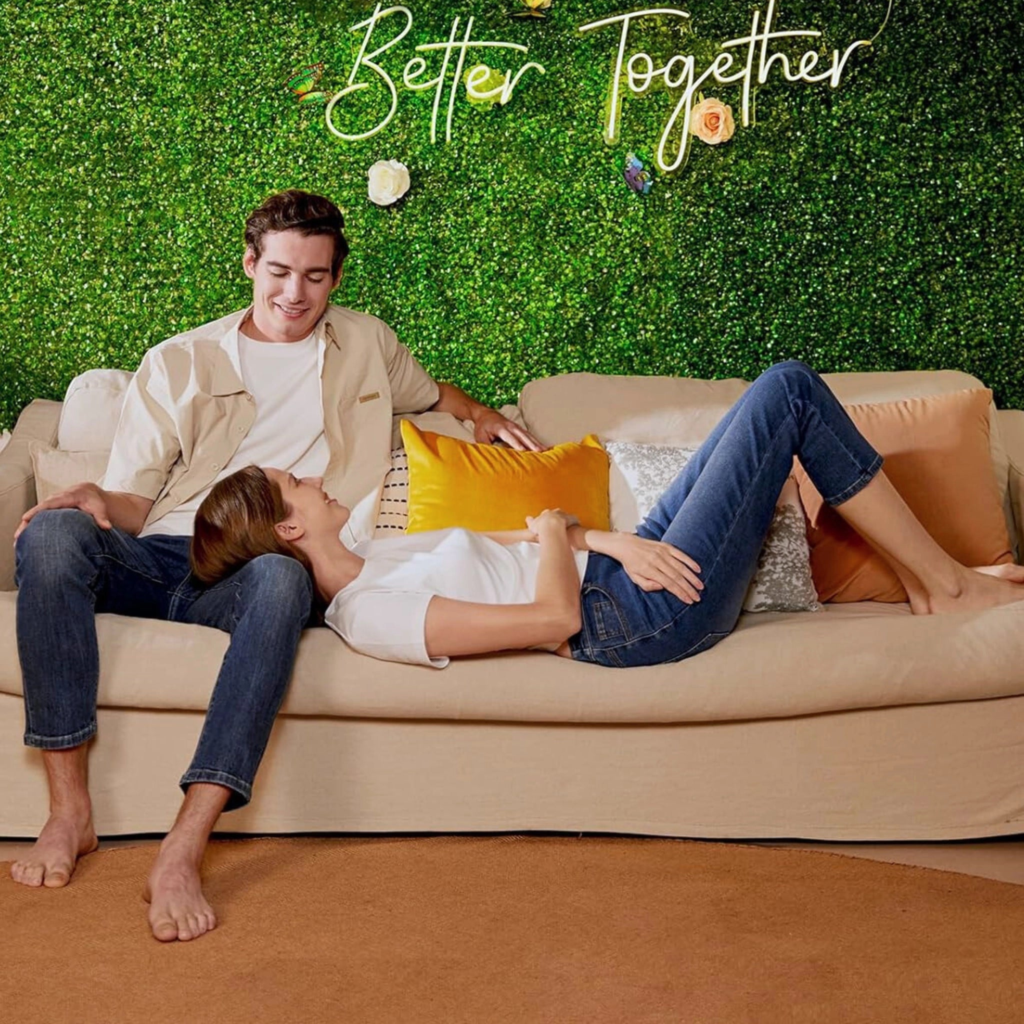 Couple relaxing on a couch with a green wall panel backdrop