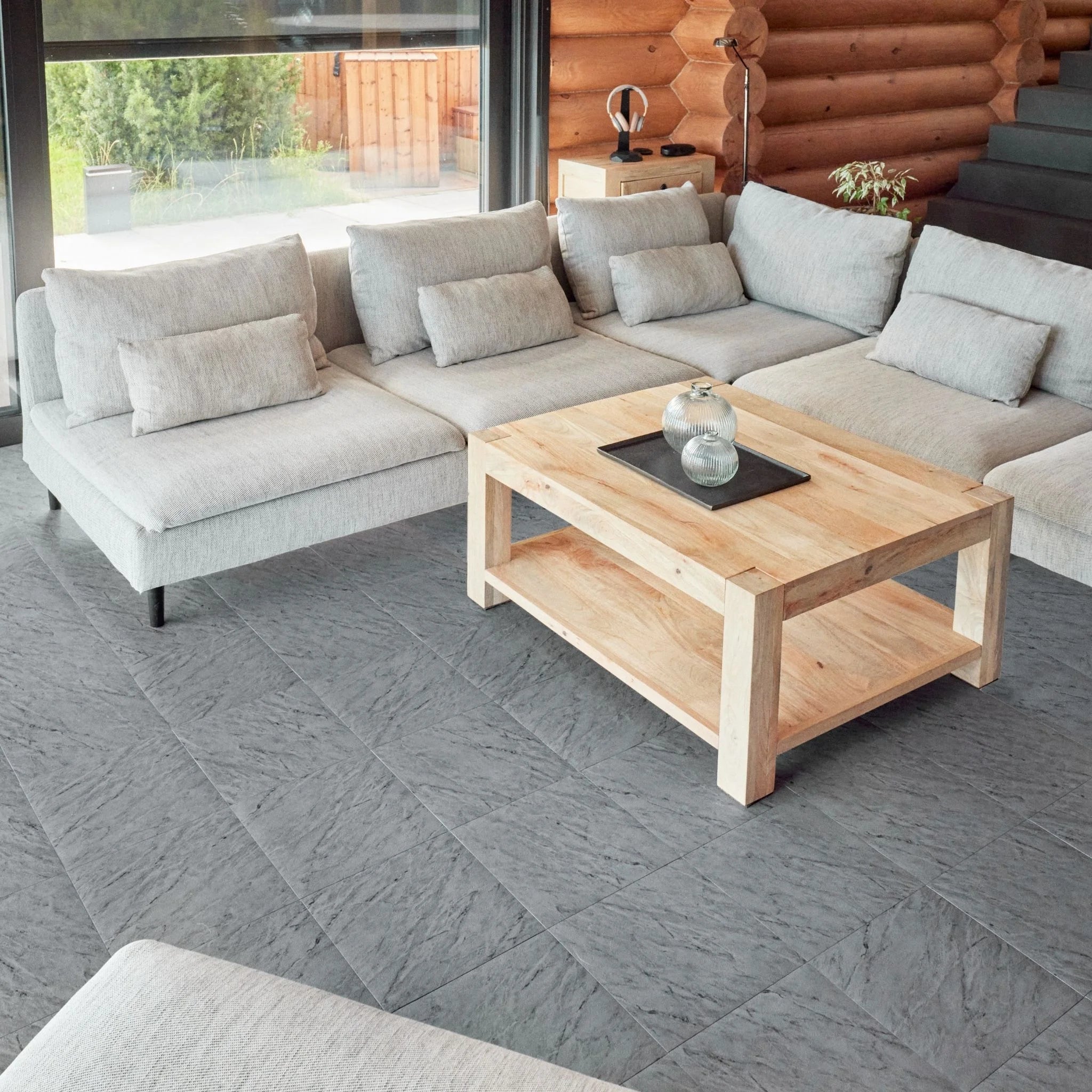 contemporary living room with large beige sofa, wooden coffee table, and grey tile flooring