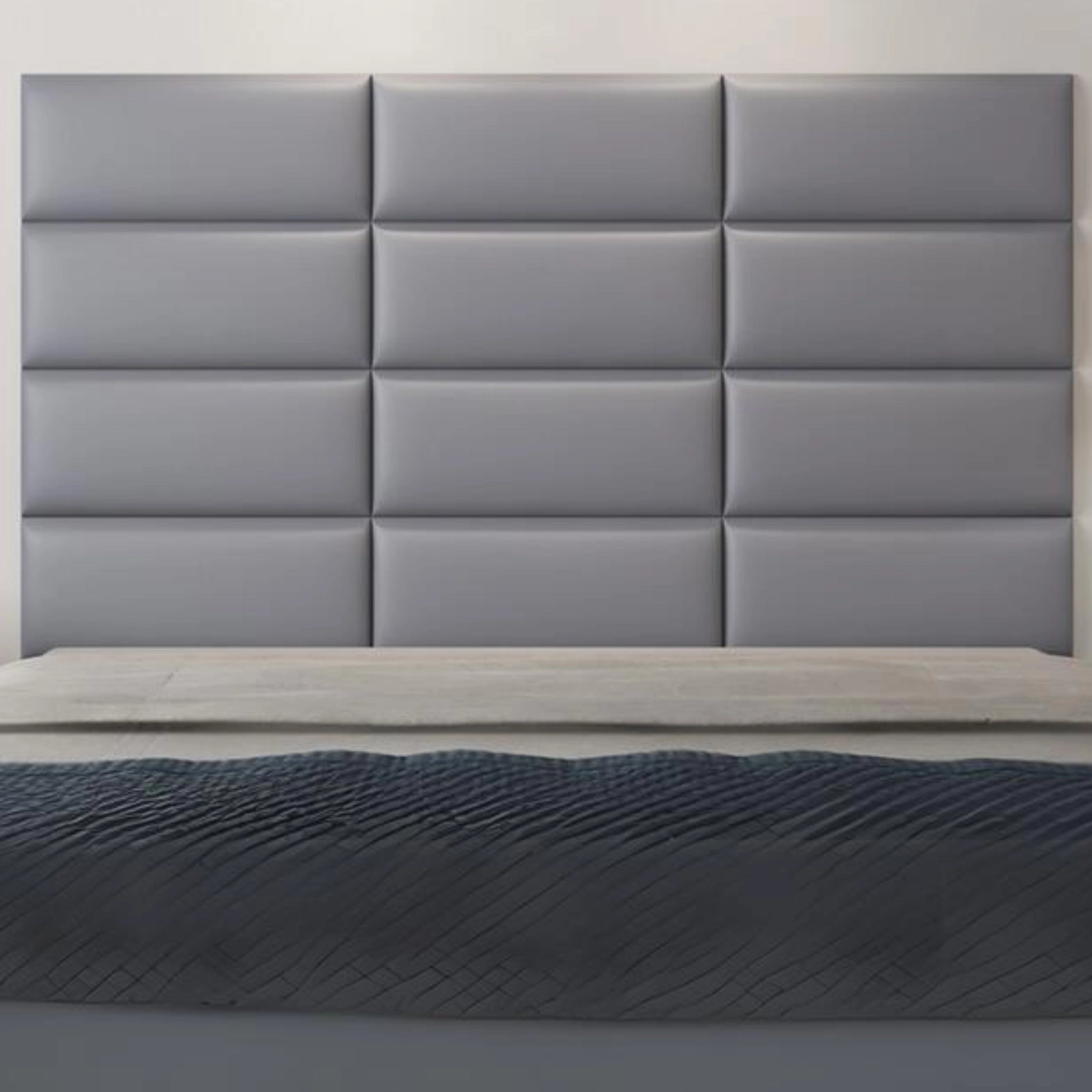 Modern bedroom with grey upholstered wall panel featuring padded surface 