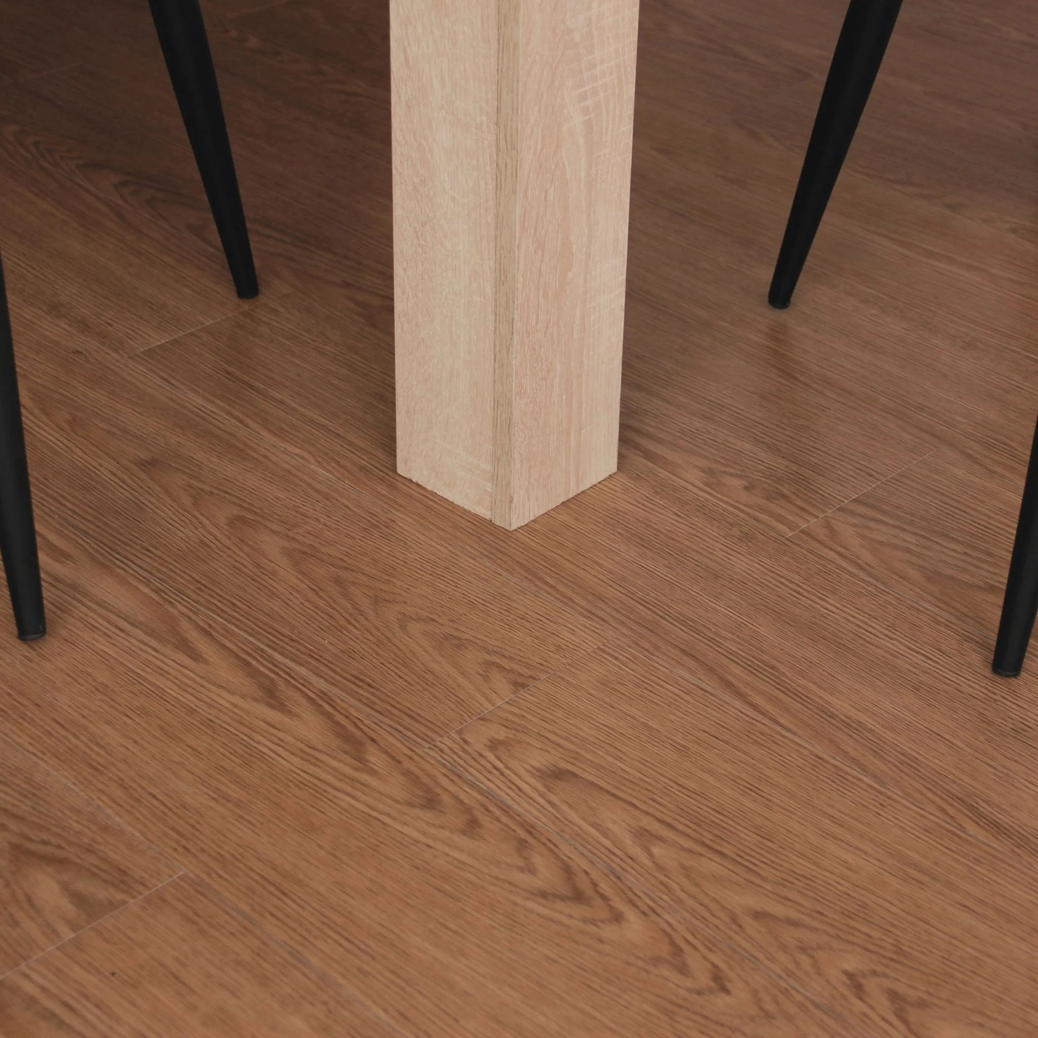 light brown wood effect vinyl flooring under a table and black metal chairs