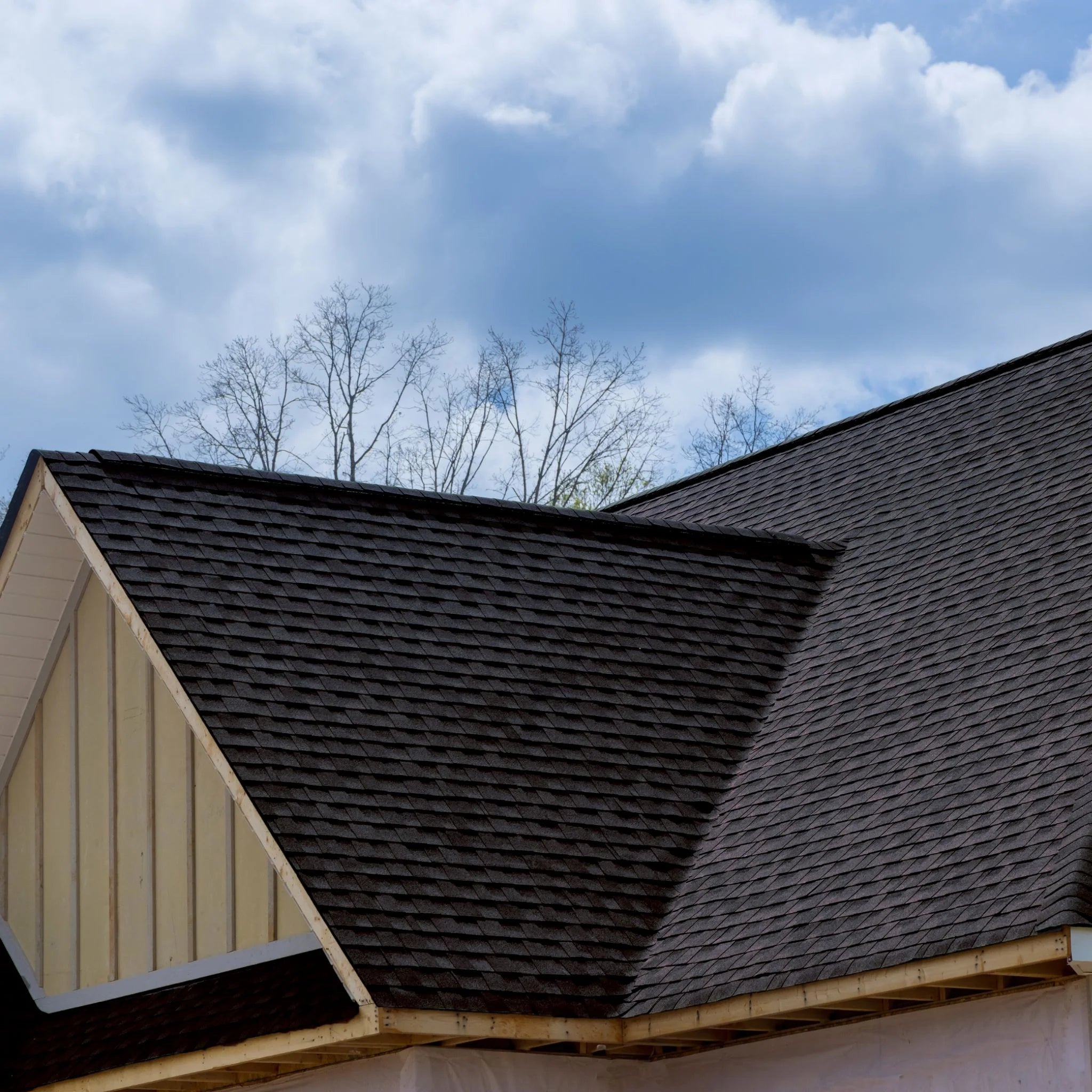 roof with installed graphite shingles against sky