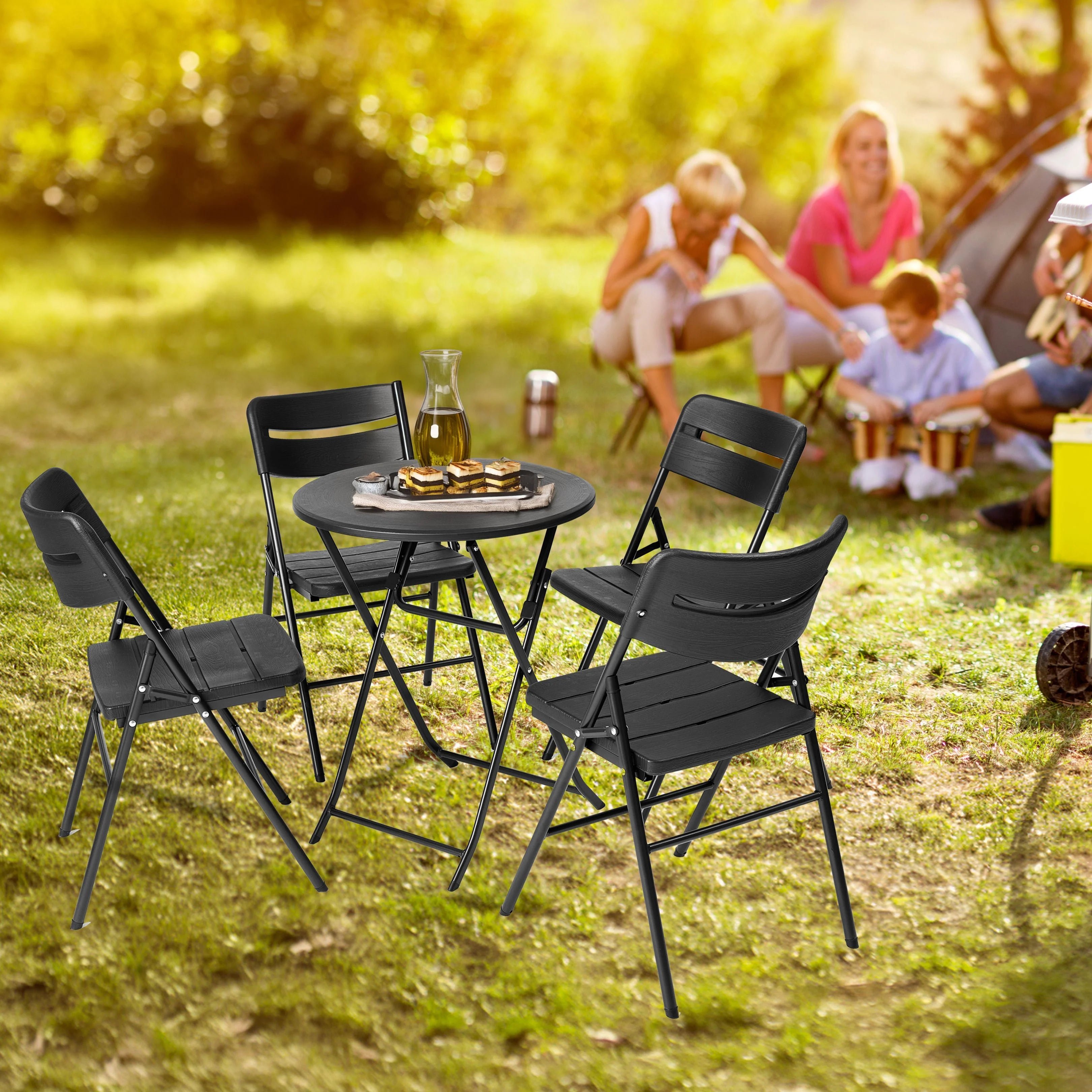 black round folding table and chair in use at outdoor barbecue