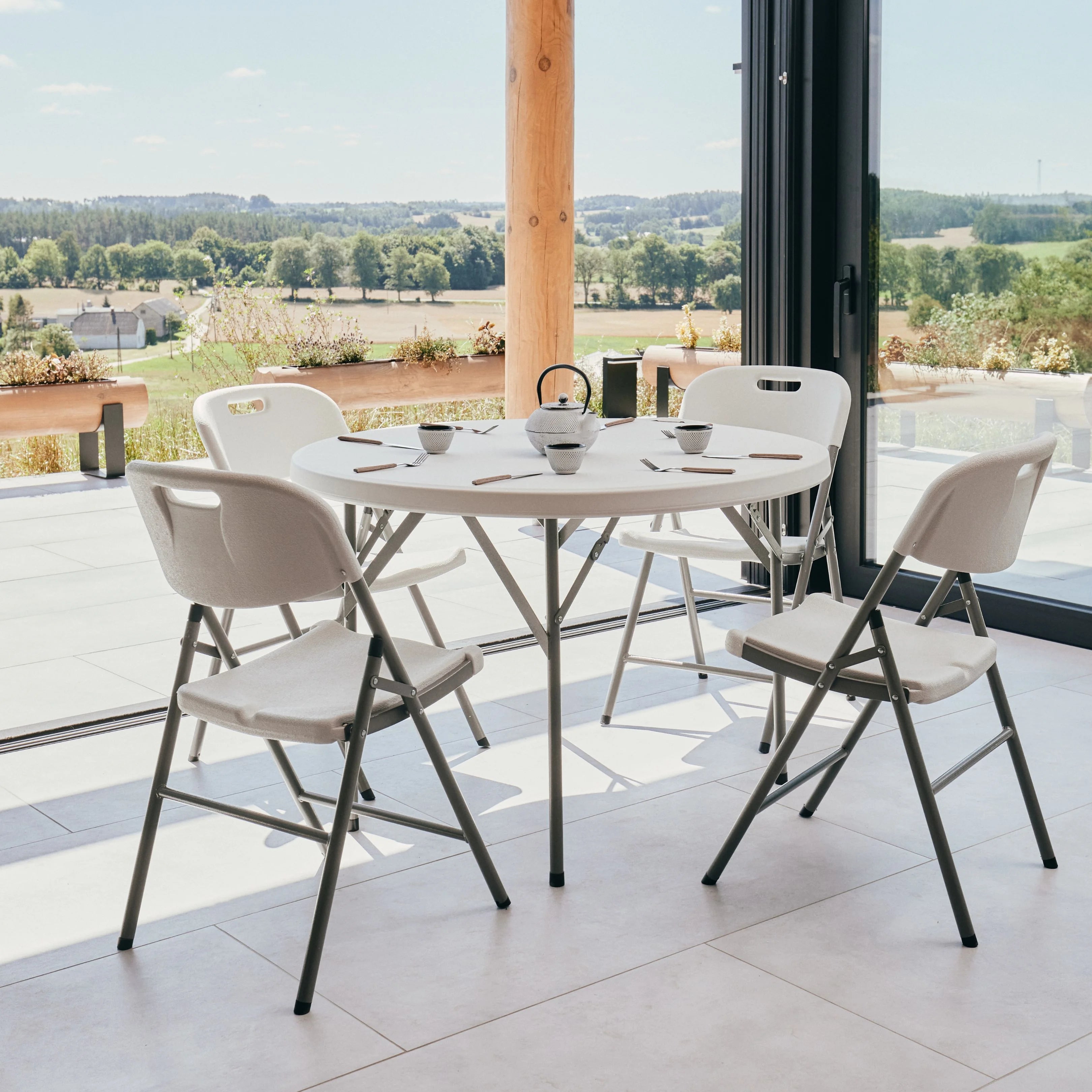 white round folding table and chairs on patio with tea pot