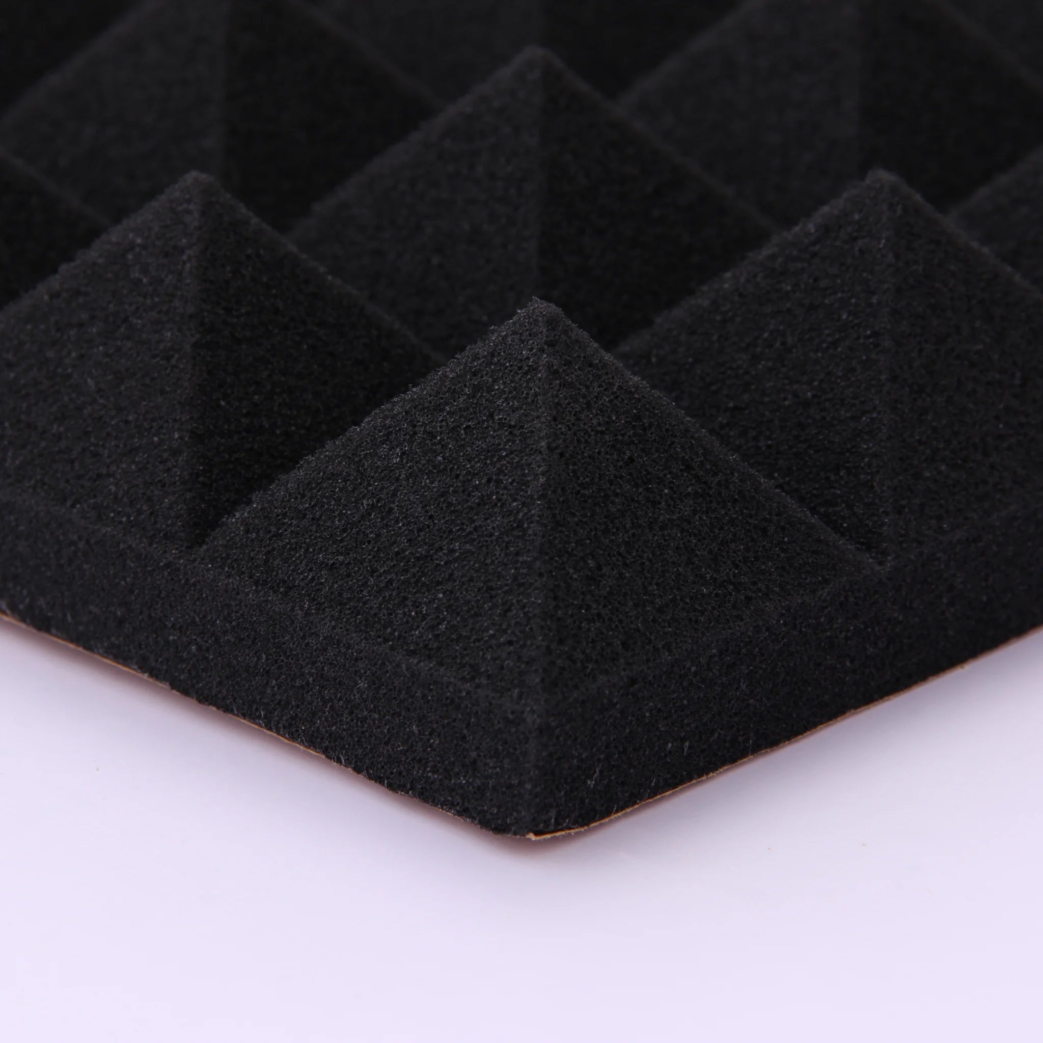 A close-up of a black pyramid foam panel non-toxic material