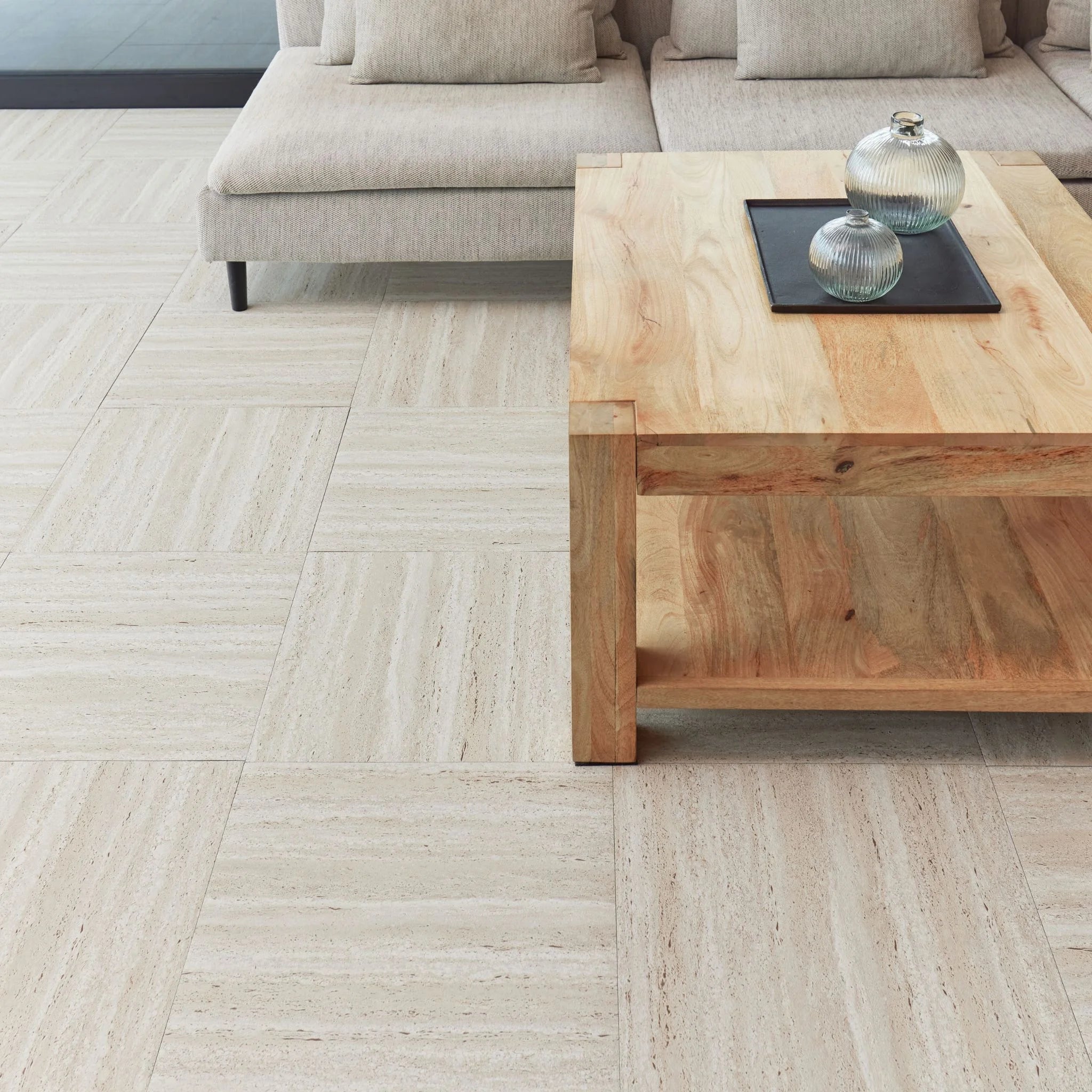 modern living room featuring grey sofa and light wood furniture on travertine beige flooring